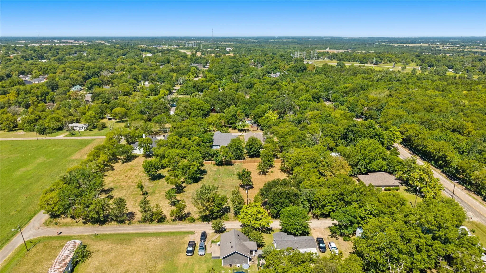 Expansive land parcel featuring mature trees, open clearings, and perimeter roads