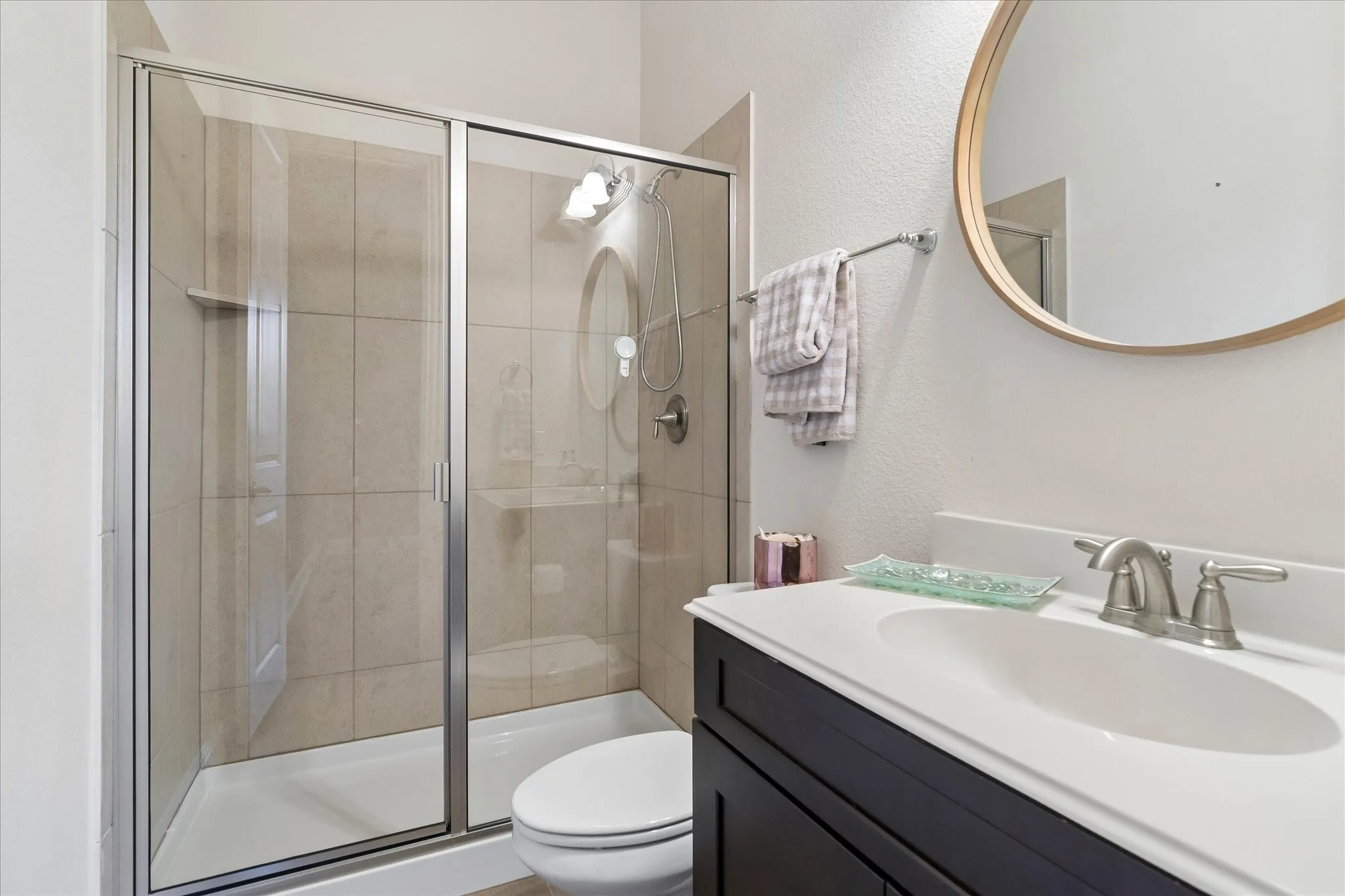 Shower enclosure with sliding glass doors, tile surround, and built-in niche