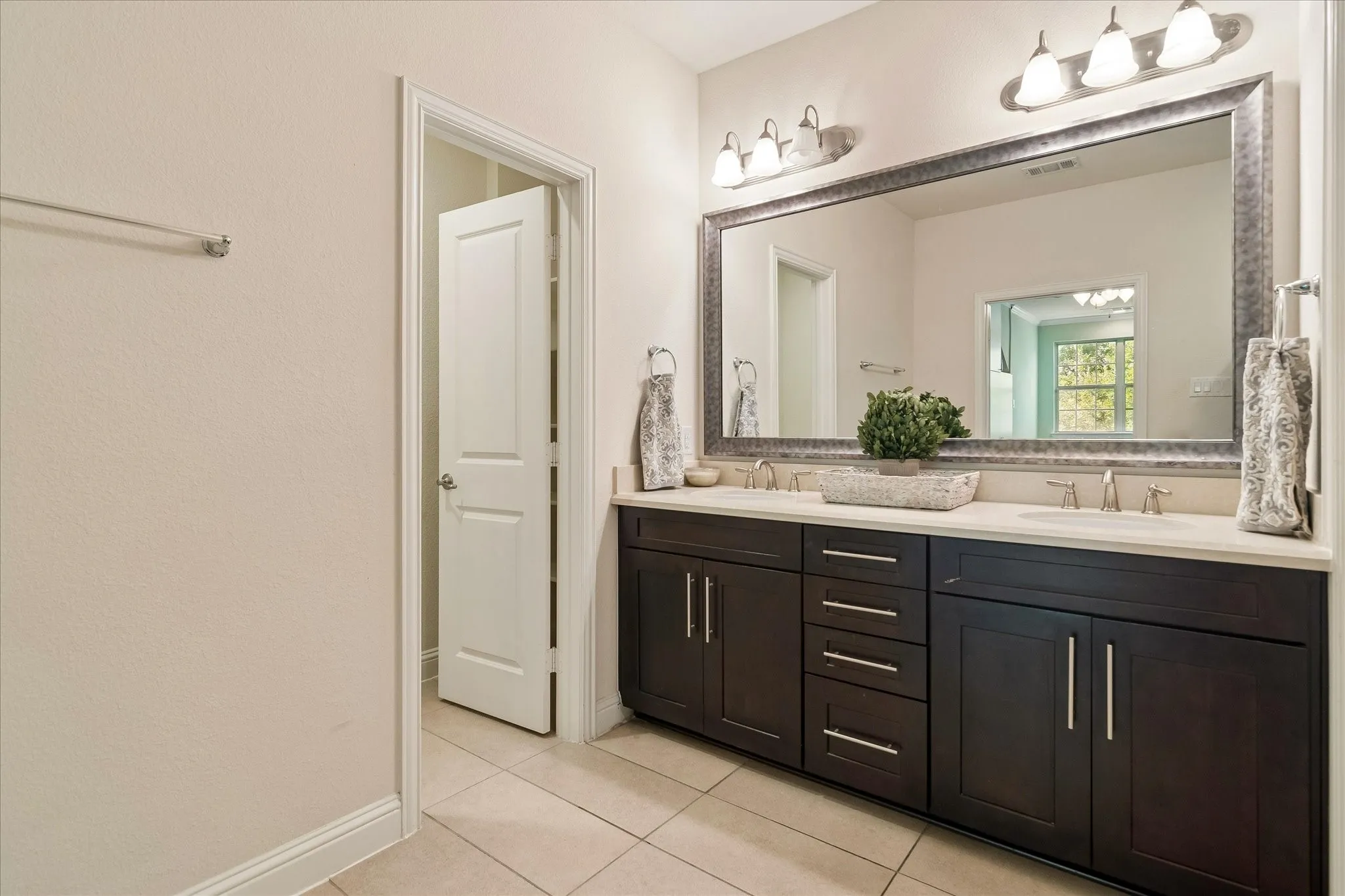 Dual vanity with dark wood-finish cabinetry, light-toned countertop, and undermount sinks