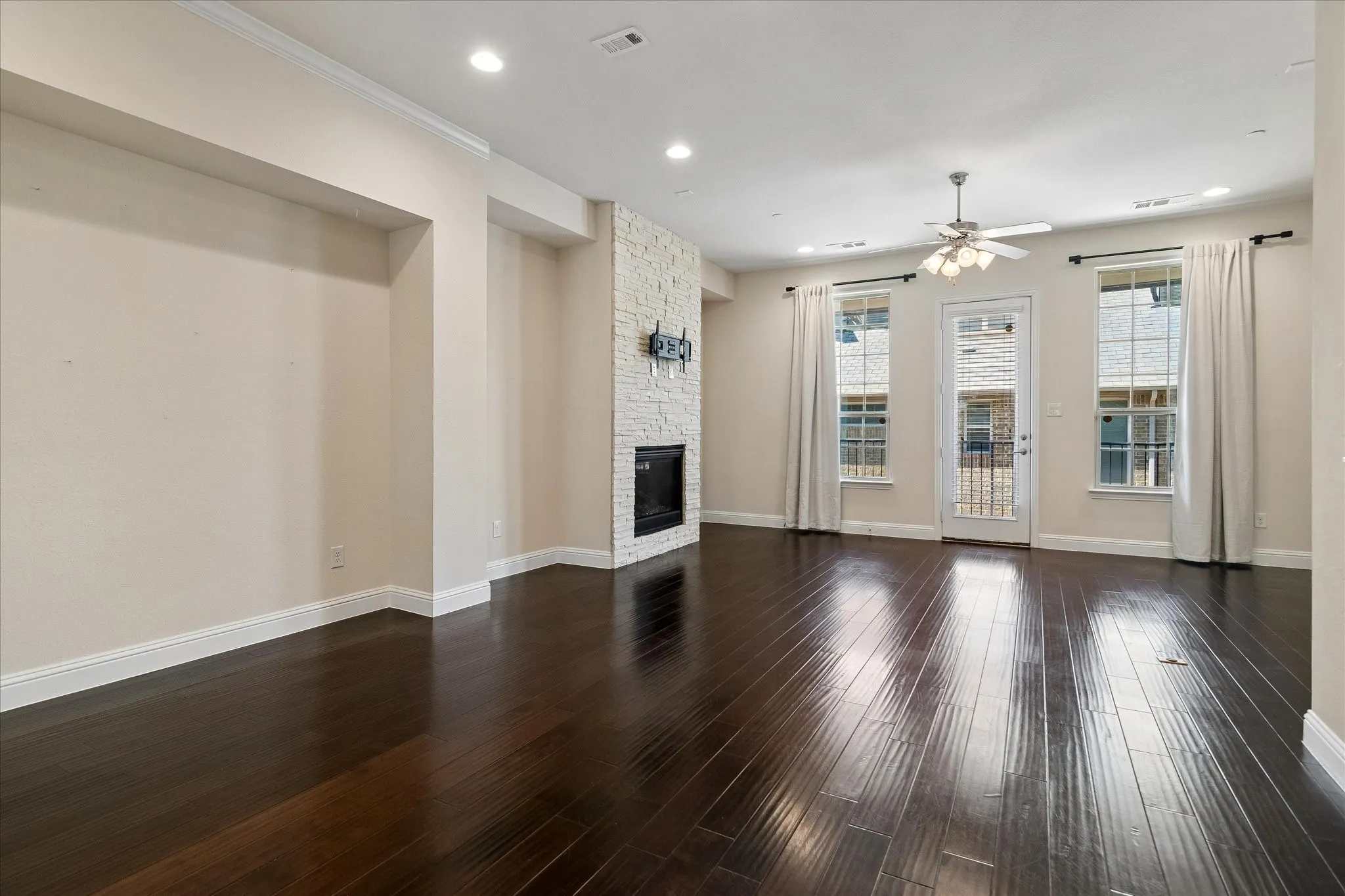 Dark wood-finish flooring, recessed lighting, and crown molding