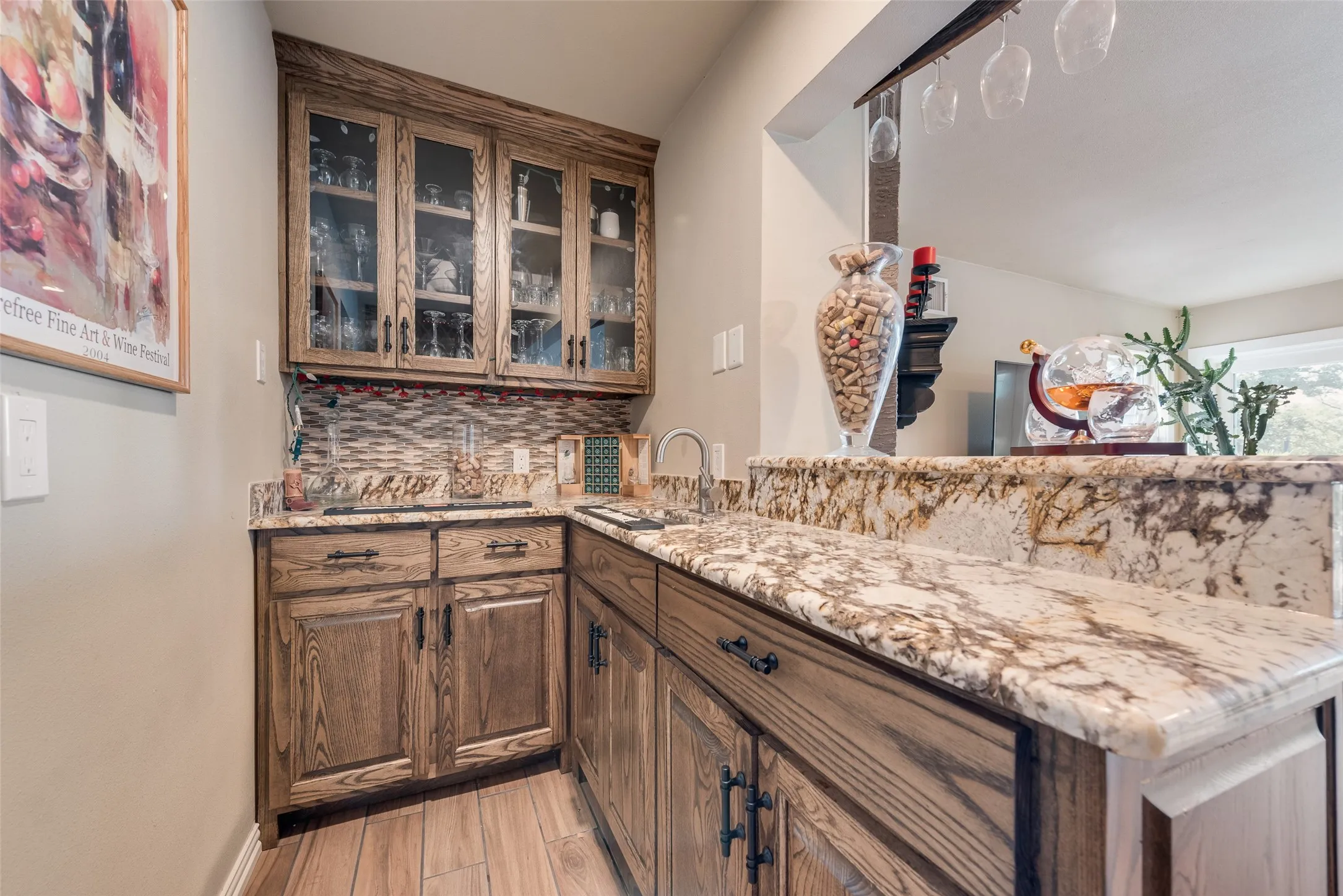 Built-in bar area featuring glass-front upper cabinetry, wood-finish lower cabinetry, and stone countertops