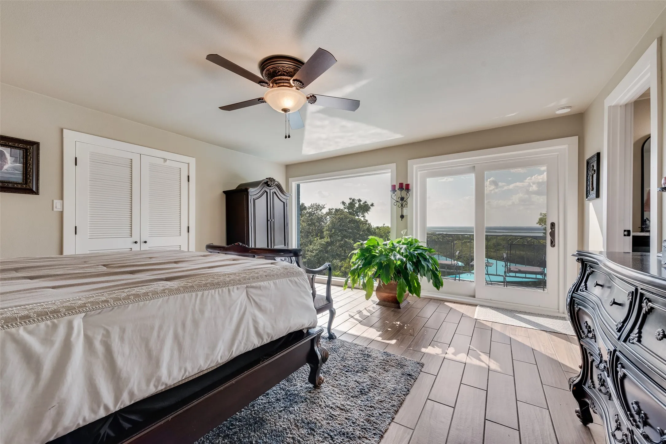 Wood-finish flooring, sliding glass doors, white trim, ceiling fan, and built-in closet doors