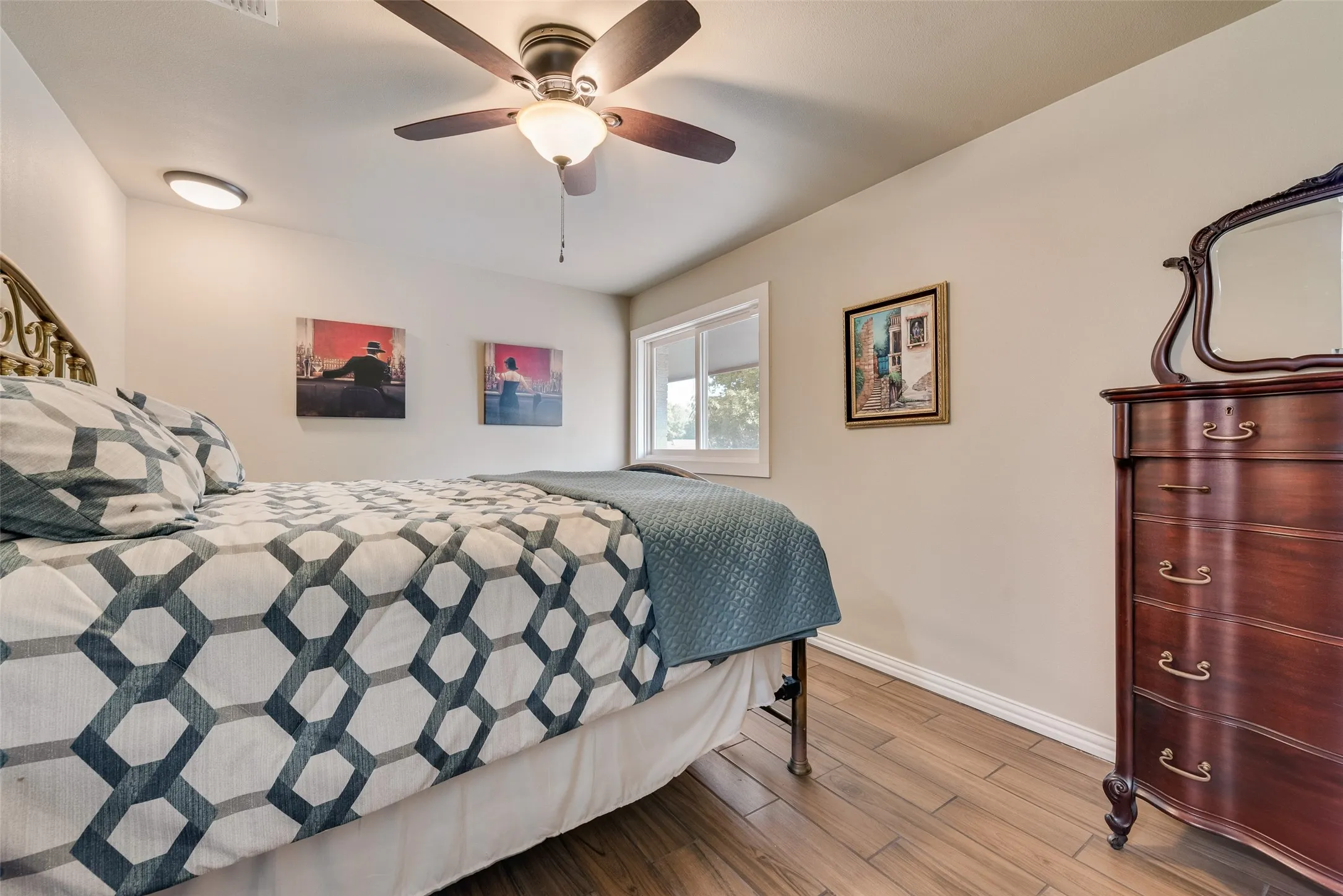 Wood-finish flooring, ceiling fan with integrated lighting, recessed lighting, and a window providing natural light