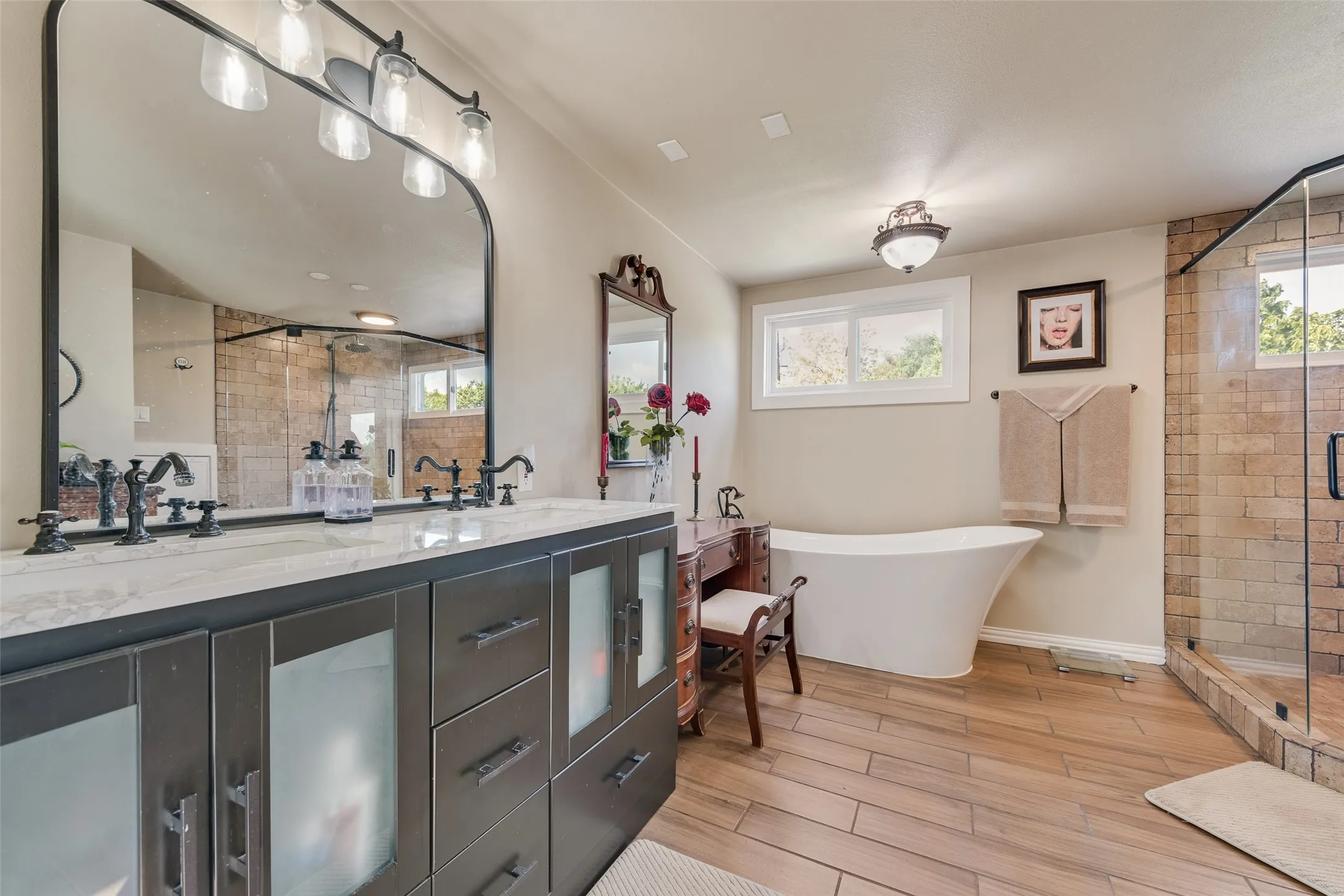 Dual vanity with dark cabinetry, white countertop, and black fixtures