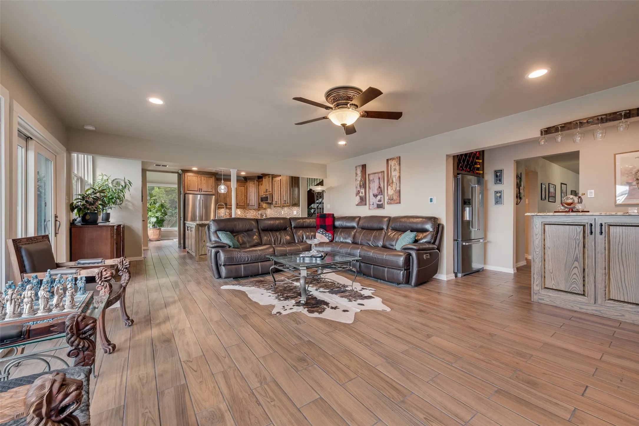 Wood-finish flooring throughout, recessed lighting, ceiling fan, and a built-in wine rack