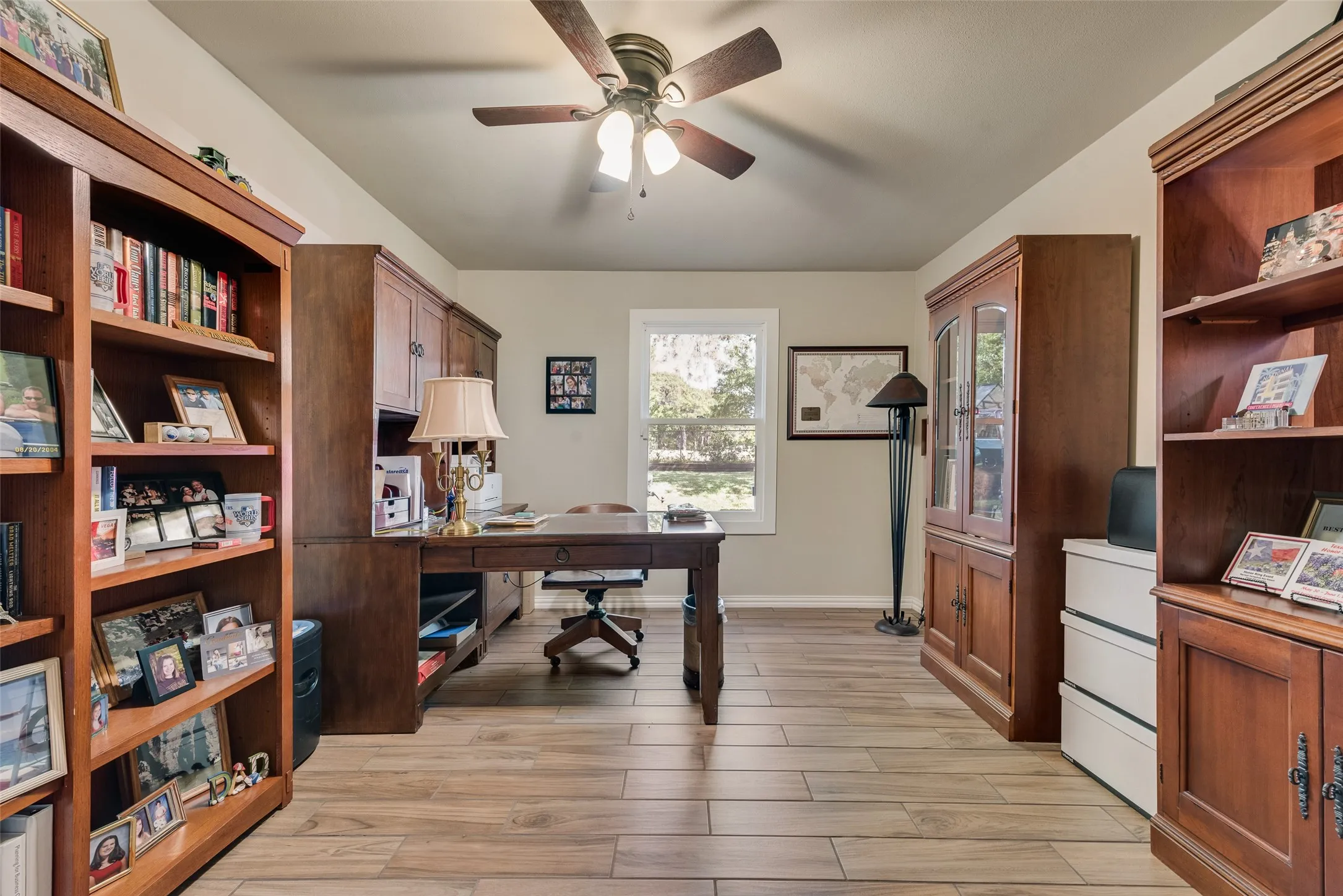 Wood-finish flooring, built-in shelving, ceiling fan with lighting, double window, and recessed lighting