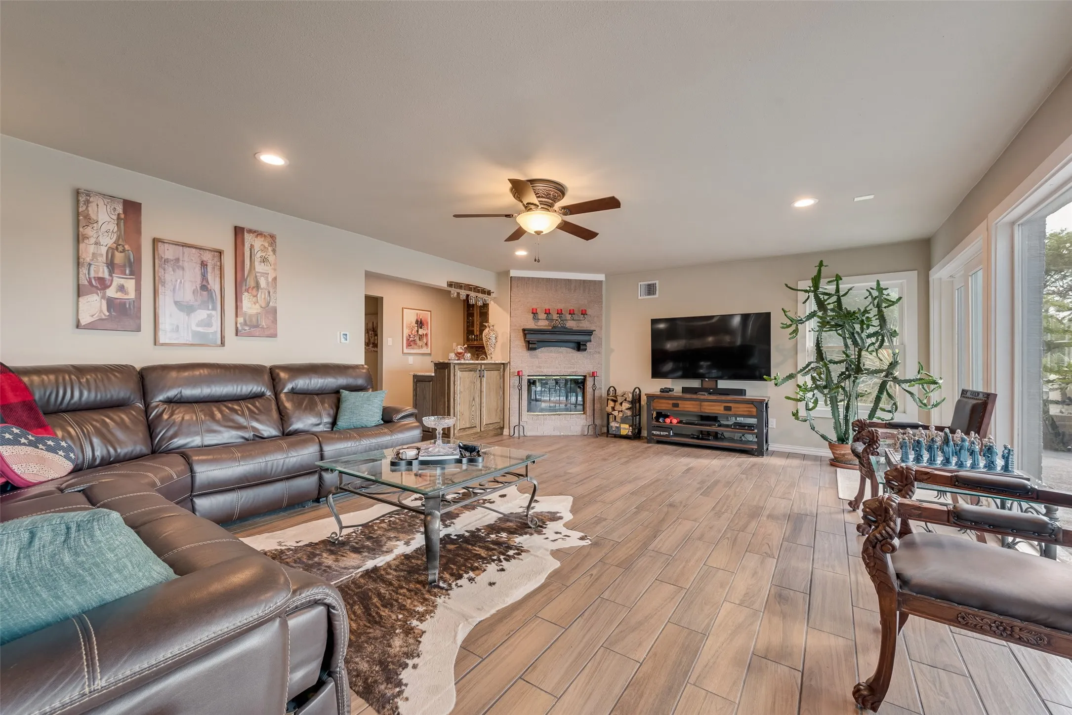 Wood-finish flooring, recessed lighting, and a ceiling fan with integrated lighting
