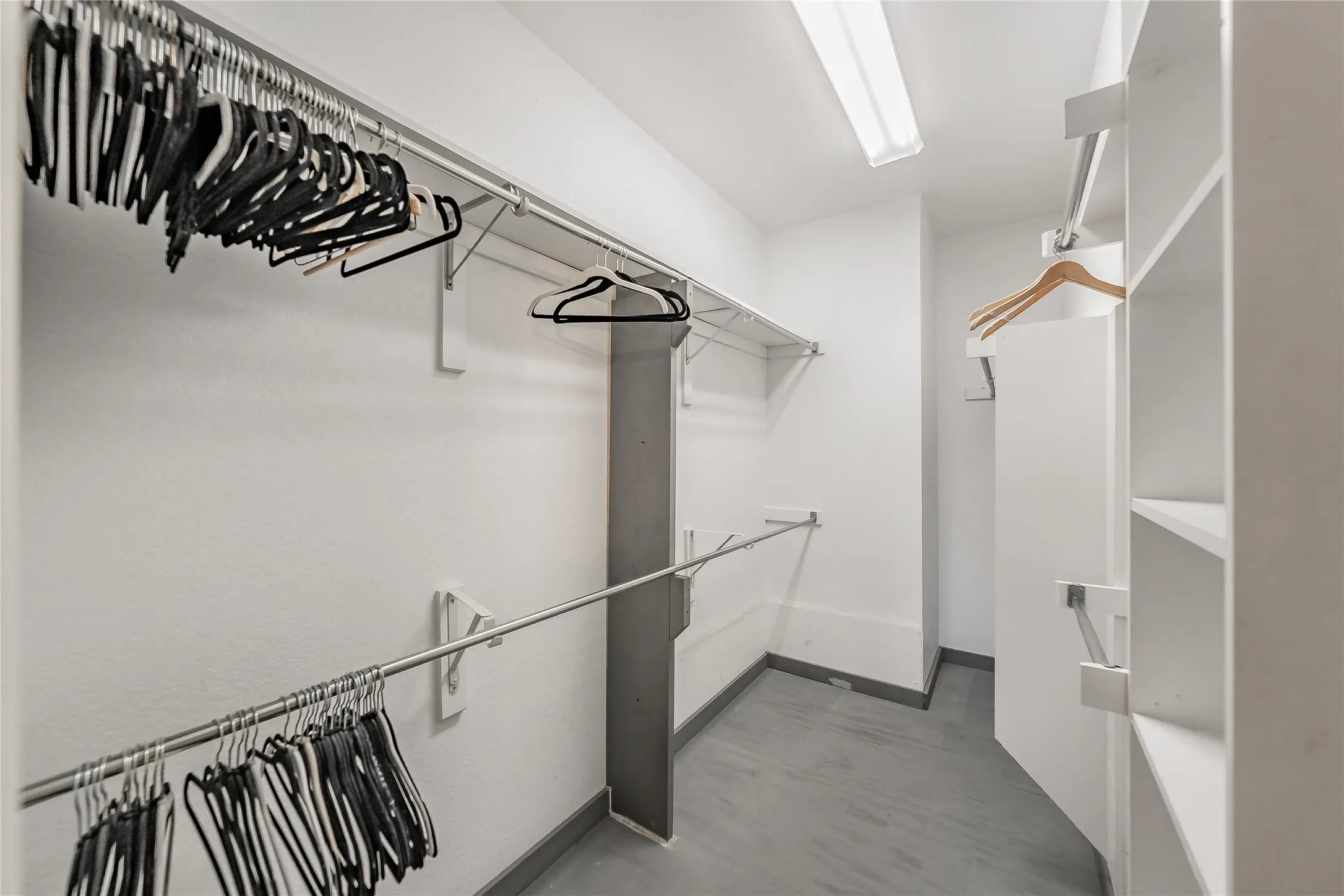 Walk-in closet featuring built-in shelving, multiple hanging rods, and recessed overhead lighting