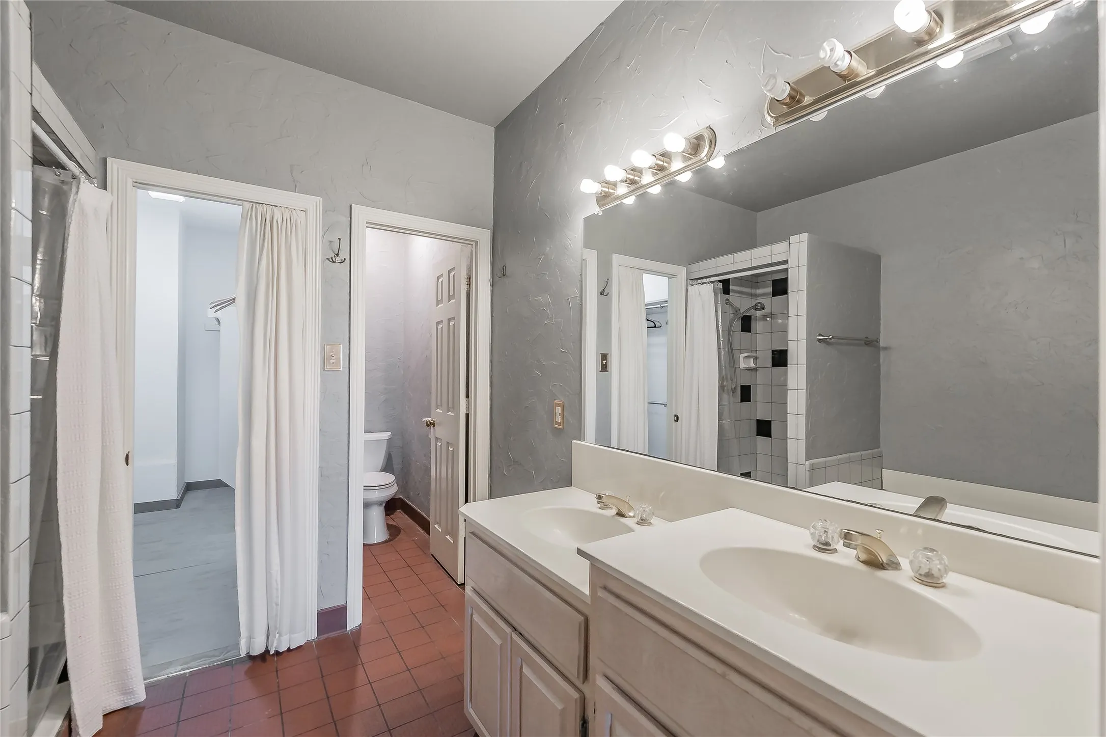 Dual vanity with undermount sinks, large wall-mounted mirror, and overhead strip lighting