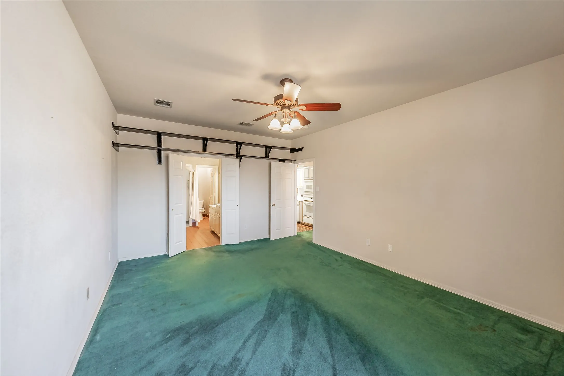 Ceiling fan with light fixture, interior doors, and wall-mounted shelving
