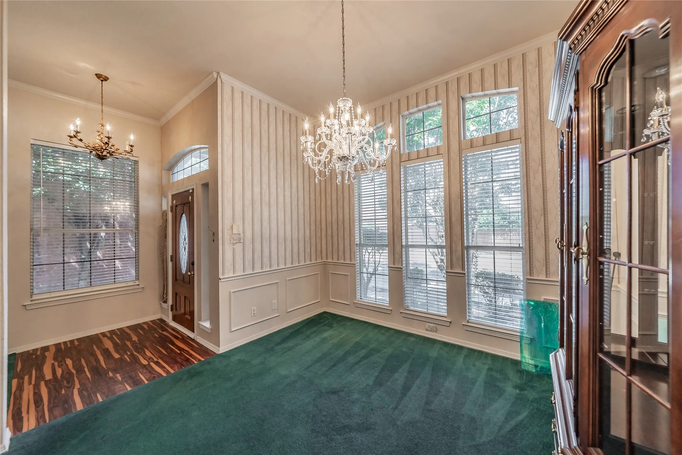 Foyer with wood-finish flooring, a decorative chandelier, and an arched transom window above the entry door