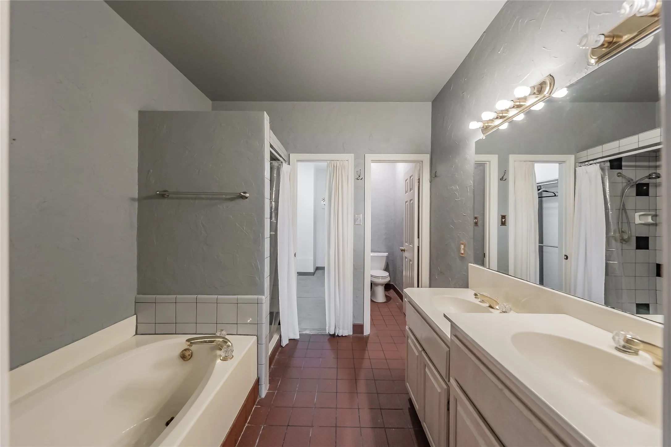Dual vanity with integrated sinks, full-width mirror, and overhead lighting