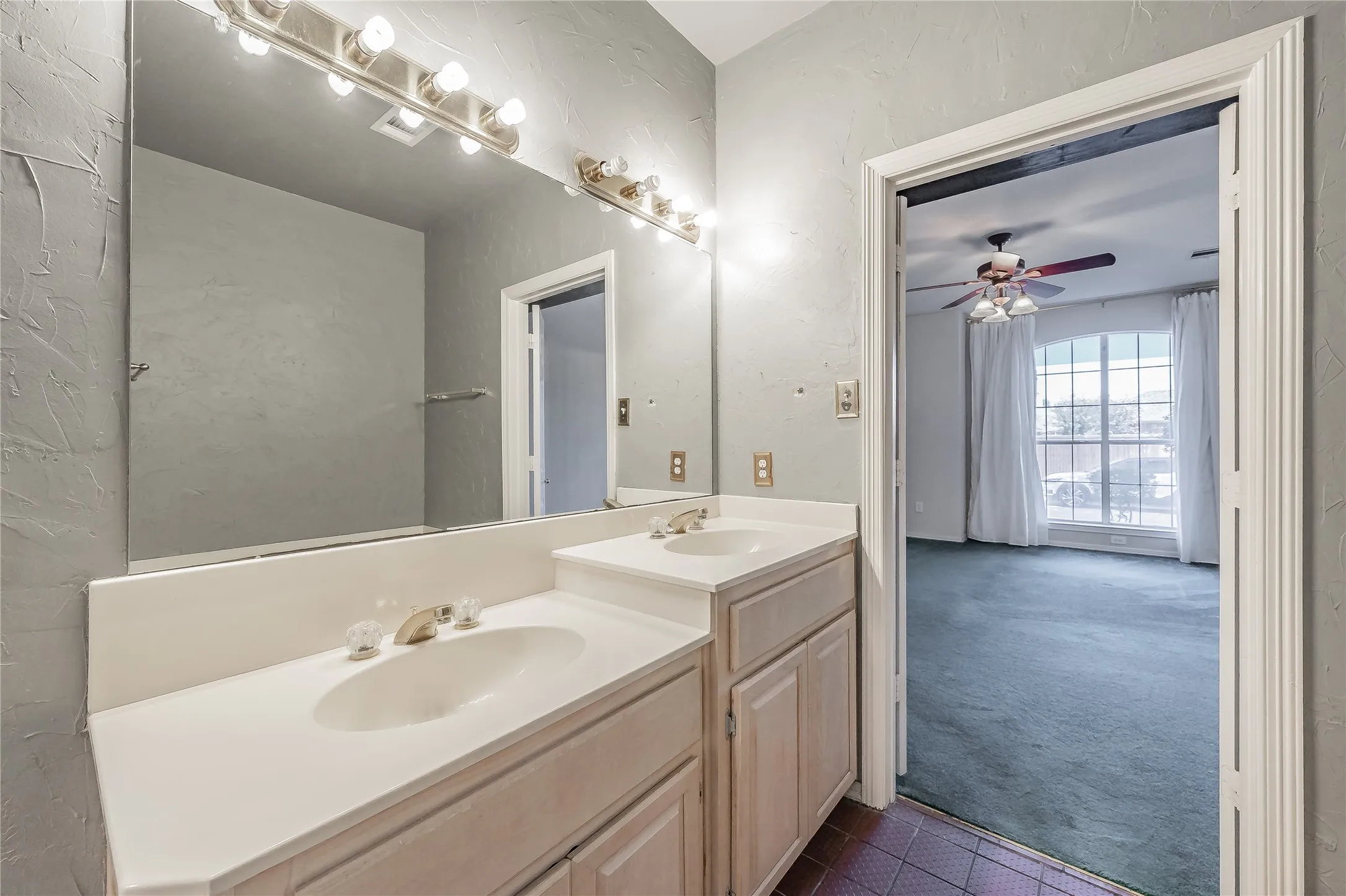 Dual vanity with integrated sinks, full-width mirror, and overhead strip lighting