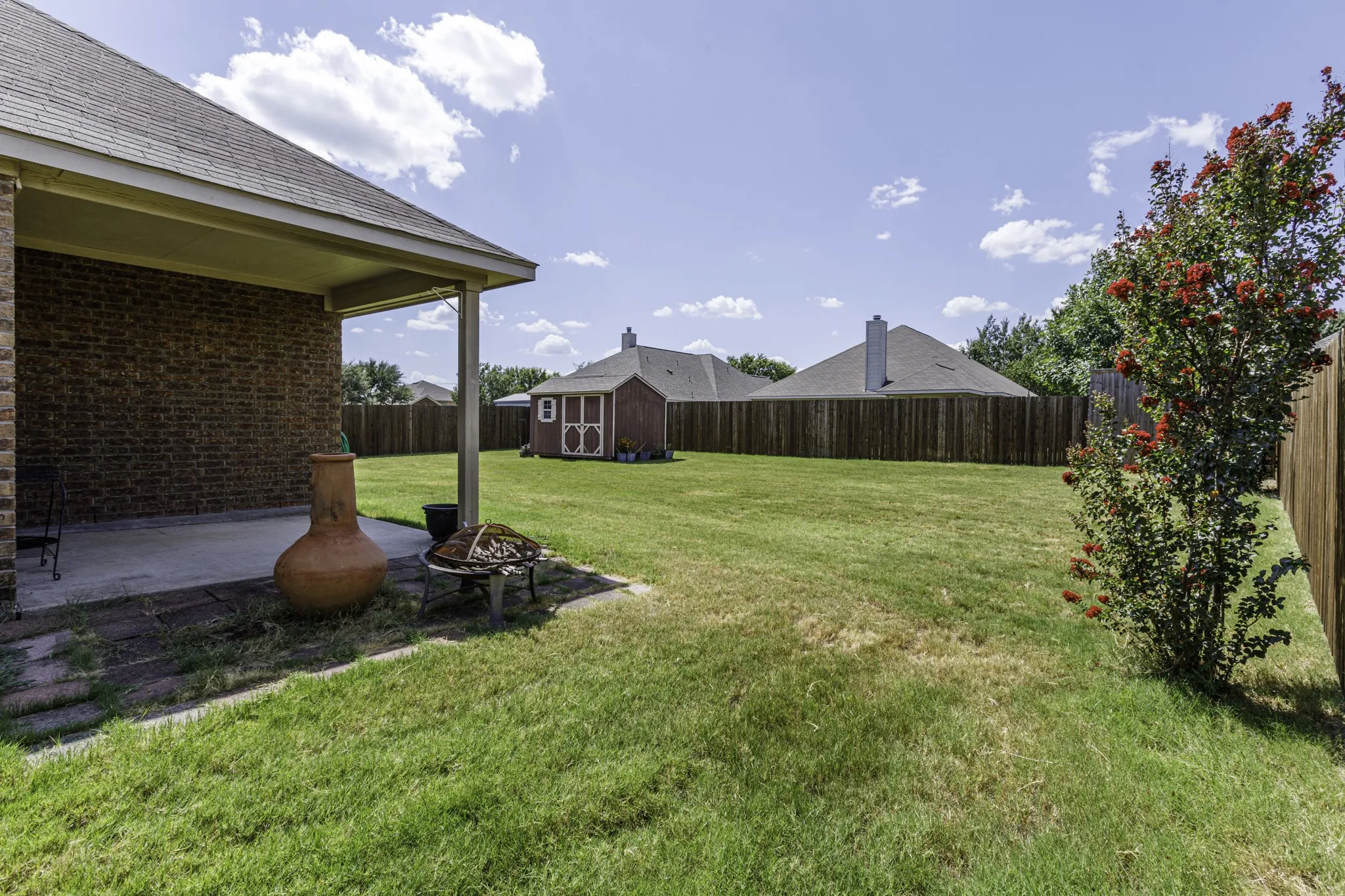 Expansive backyard with covered patio and detached outbuilding