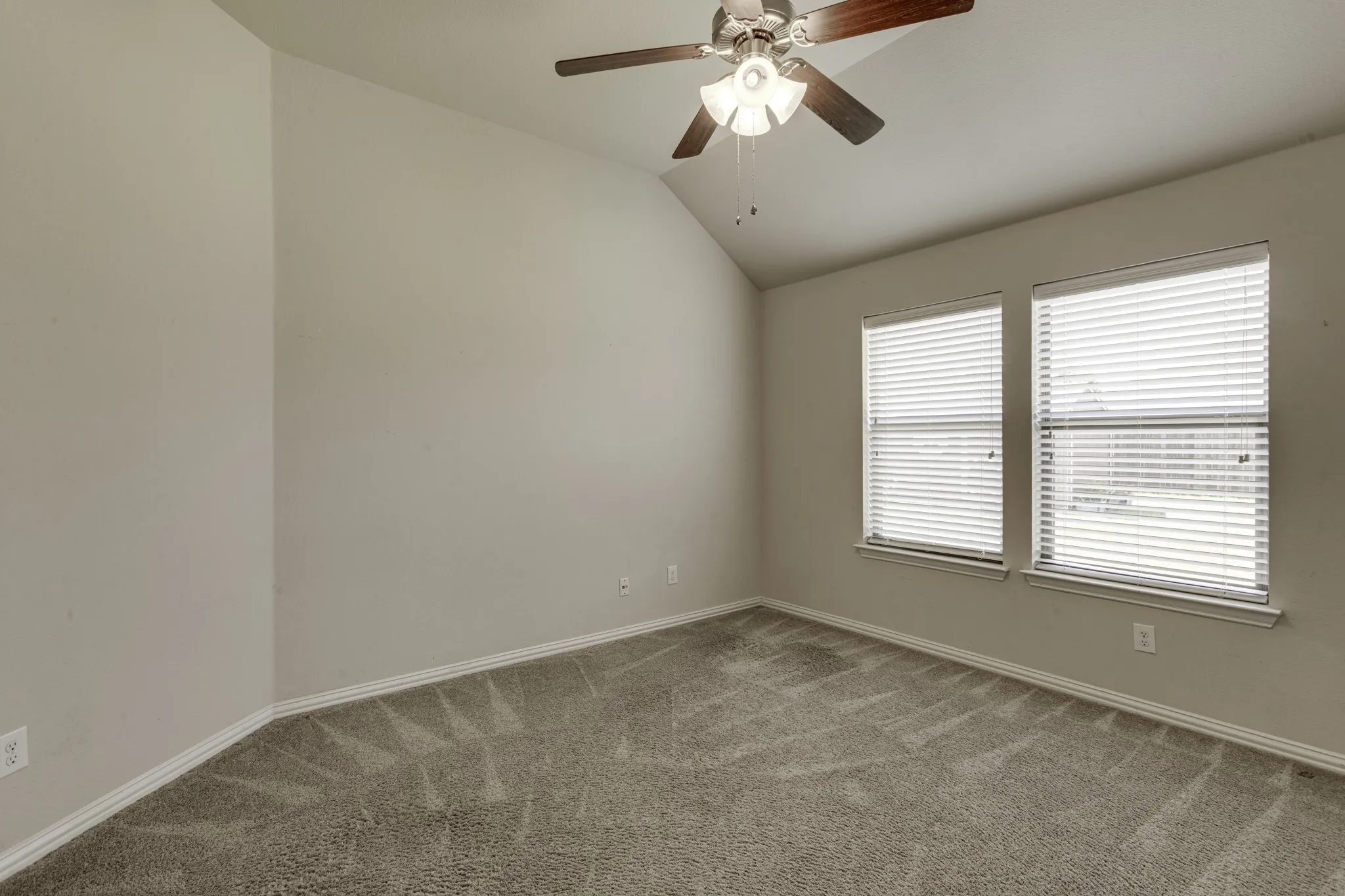 Flex space that can be a play room, or office, with bright corner thanks to the dual windows featuring horizontal blinds, neutral wall finishes, and soft carpet flooring.