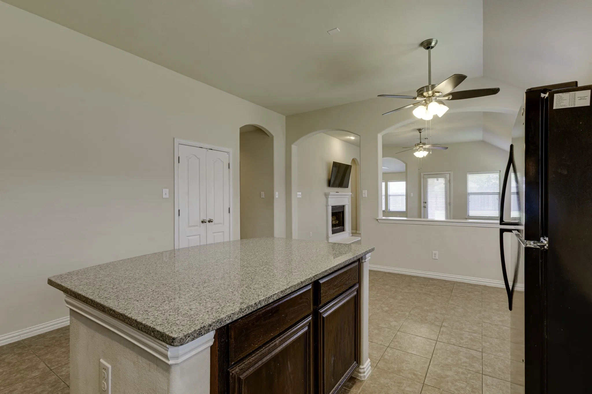Kitchen island with granite countertop and dark wood-finish cabinetry