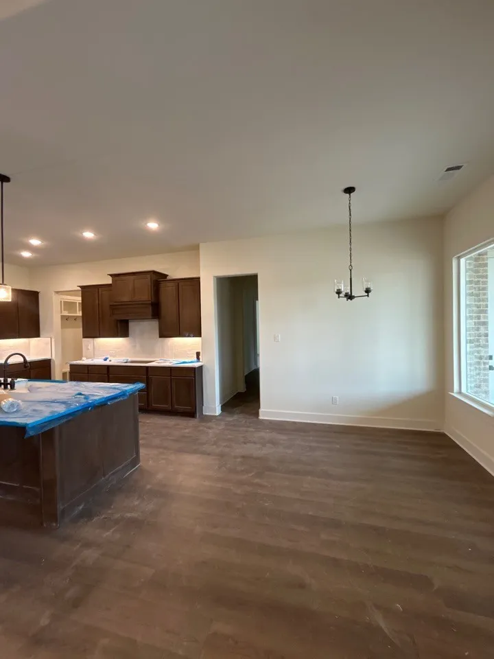 Open-concept living space featuring wood-finish flooring, recessed ceiling lighting, and a modern chandelier