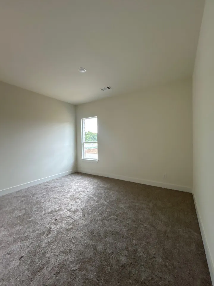 Recessed lighting, neutral wall paint, single window, and textured carpeting