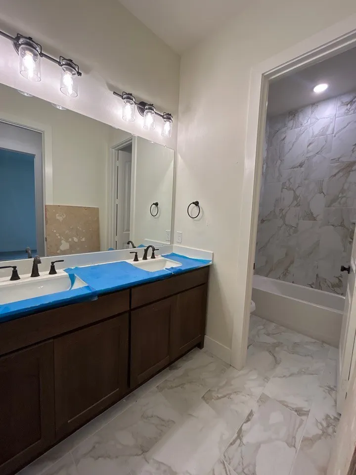 Dual vanity with dark wood-finish cabinetry, under-mount sinks, and matte black fixtures