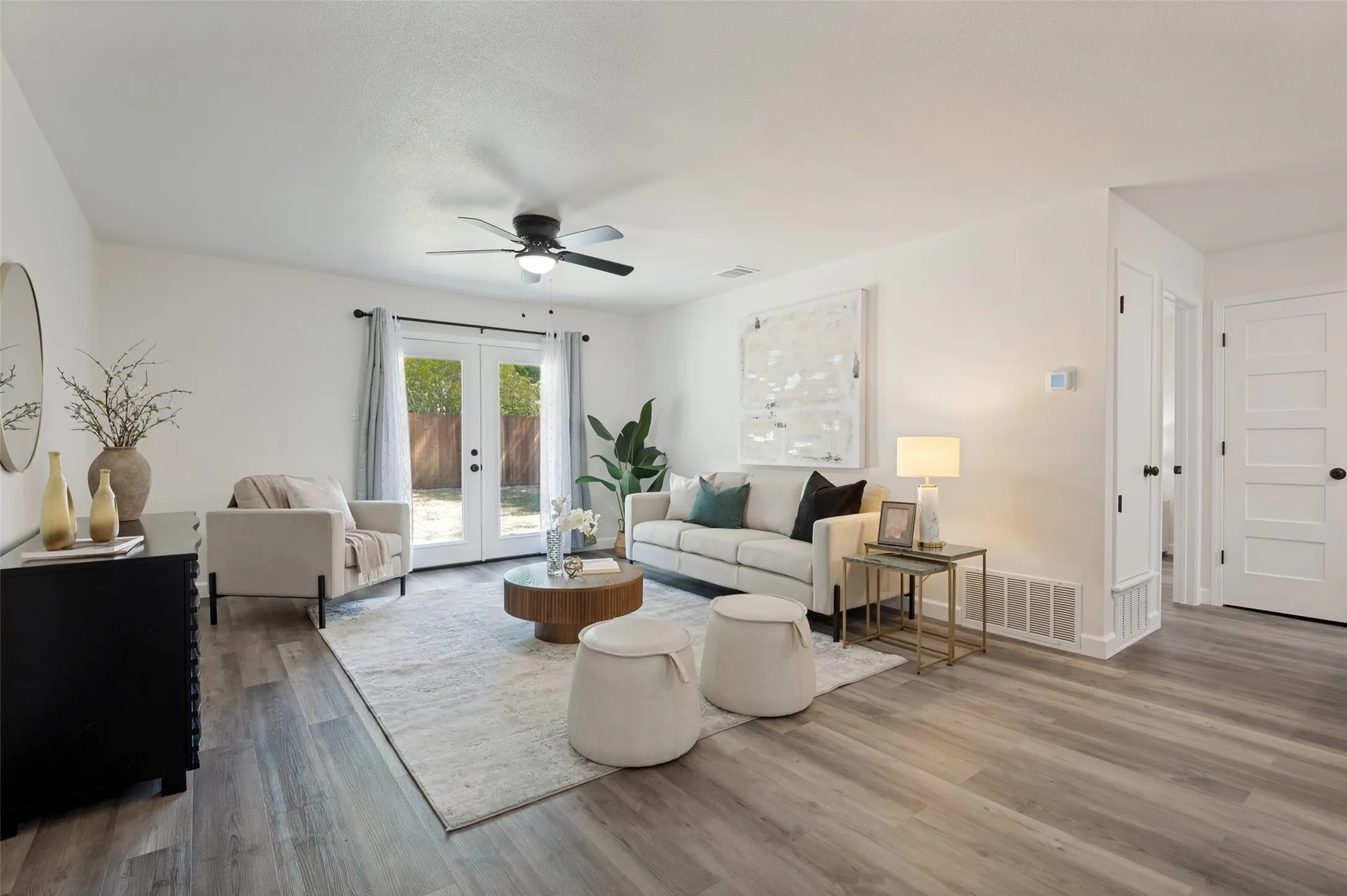 The beautifully staged living area shows off the open floor plan and abundant natural light coming in from the brand new French doors!