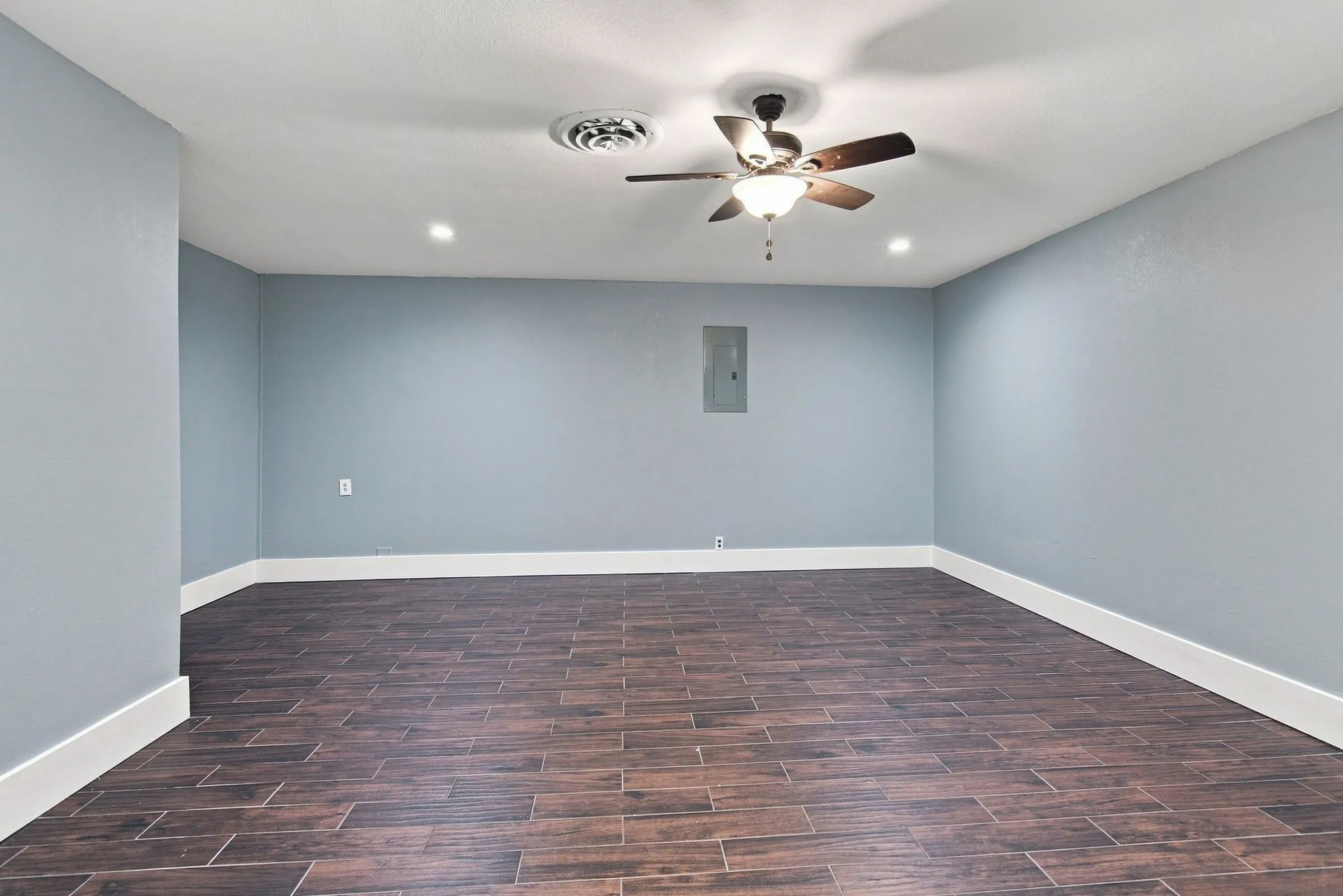 Recessed lighting, ceiling fan, wood-finish tile flooring, and light blue gray wall color