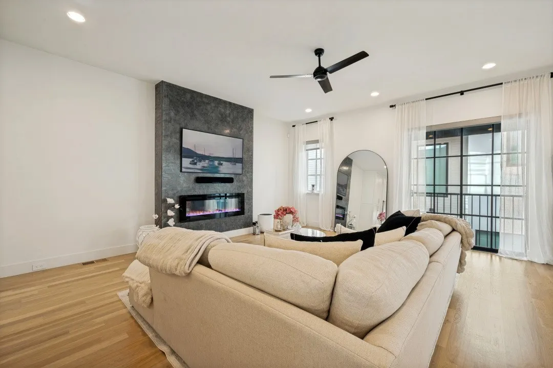 Hardwood-finish flooring throughout, featuring a modern fireplace with a dark, textured surround