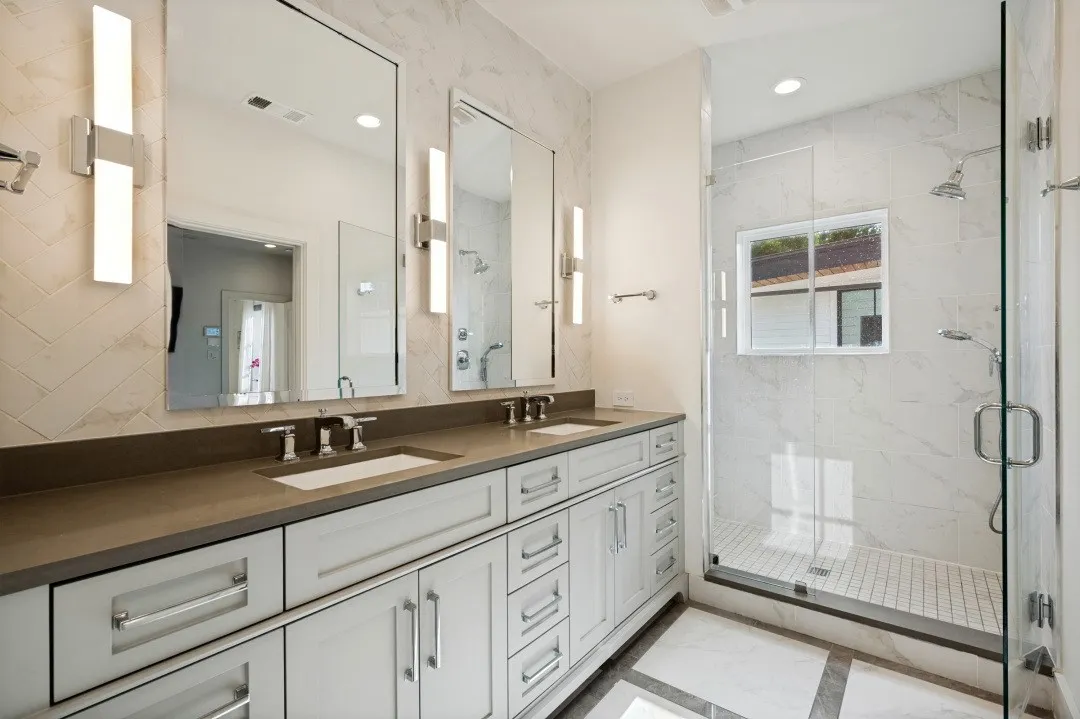 Dual vanity with undermount sinks, stone countertop, and contemporary lighting