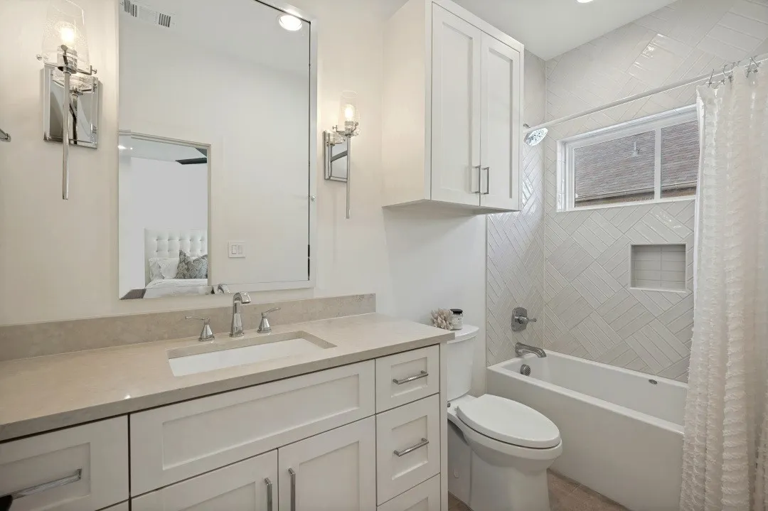 Vanity with an integrated sink, polished chrome faucet, and sconce lighting