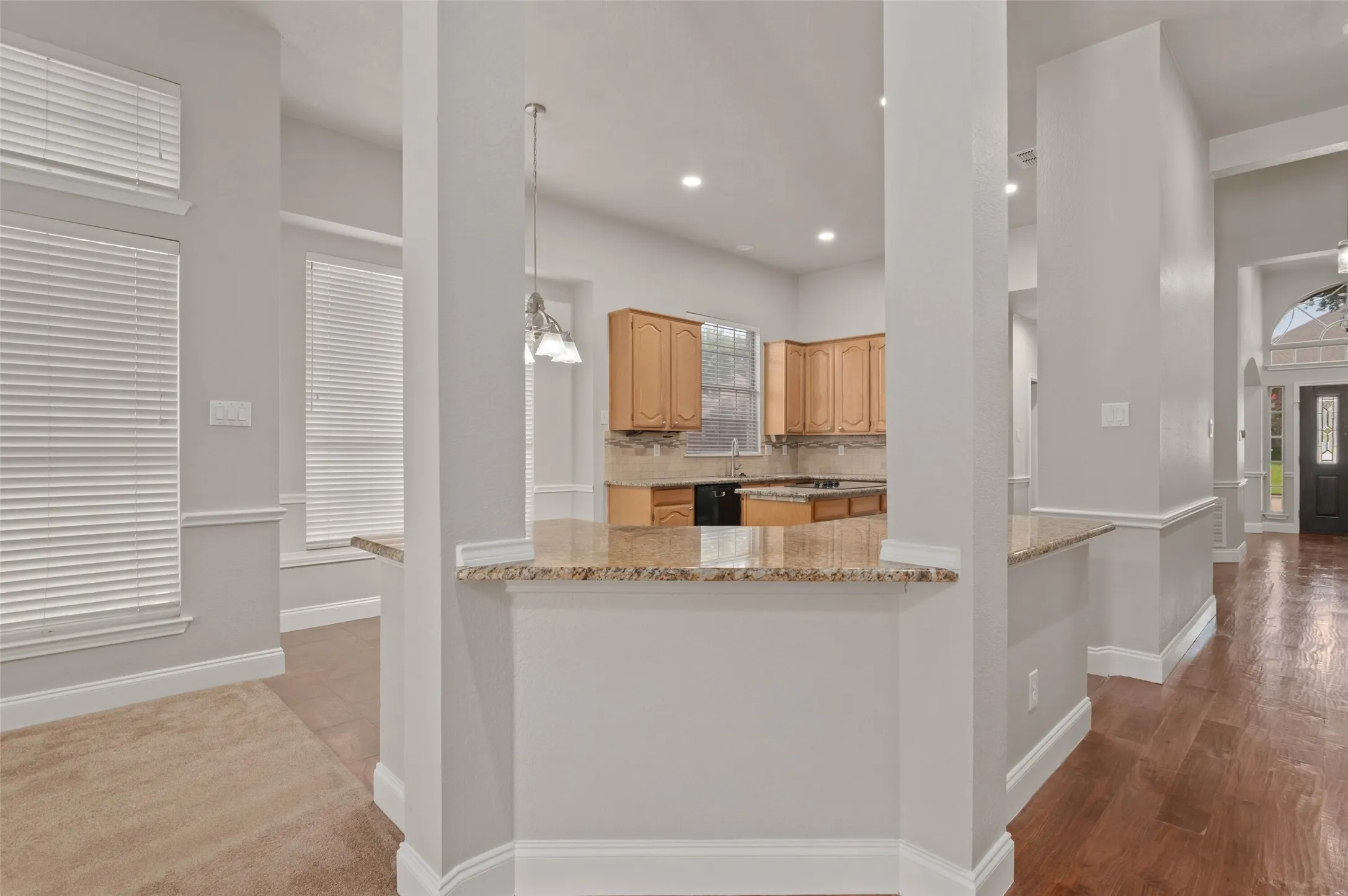 Open kitchen with granite counters, island and lots of built in cabinets.