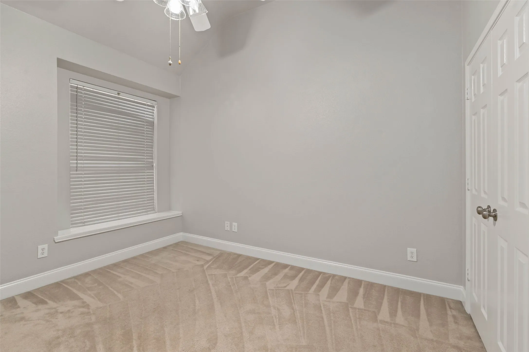 Bedroom with carpeted flooring and ceiling fan.