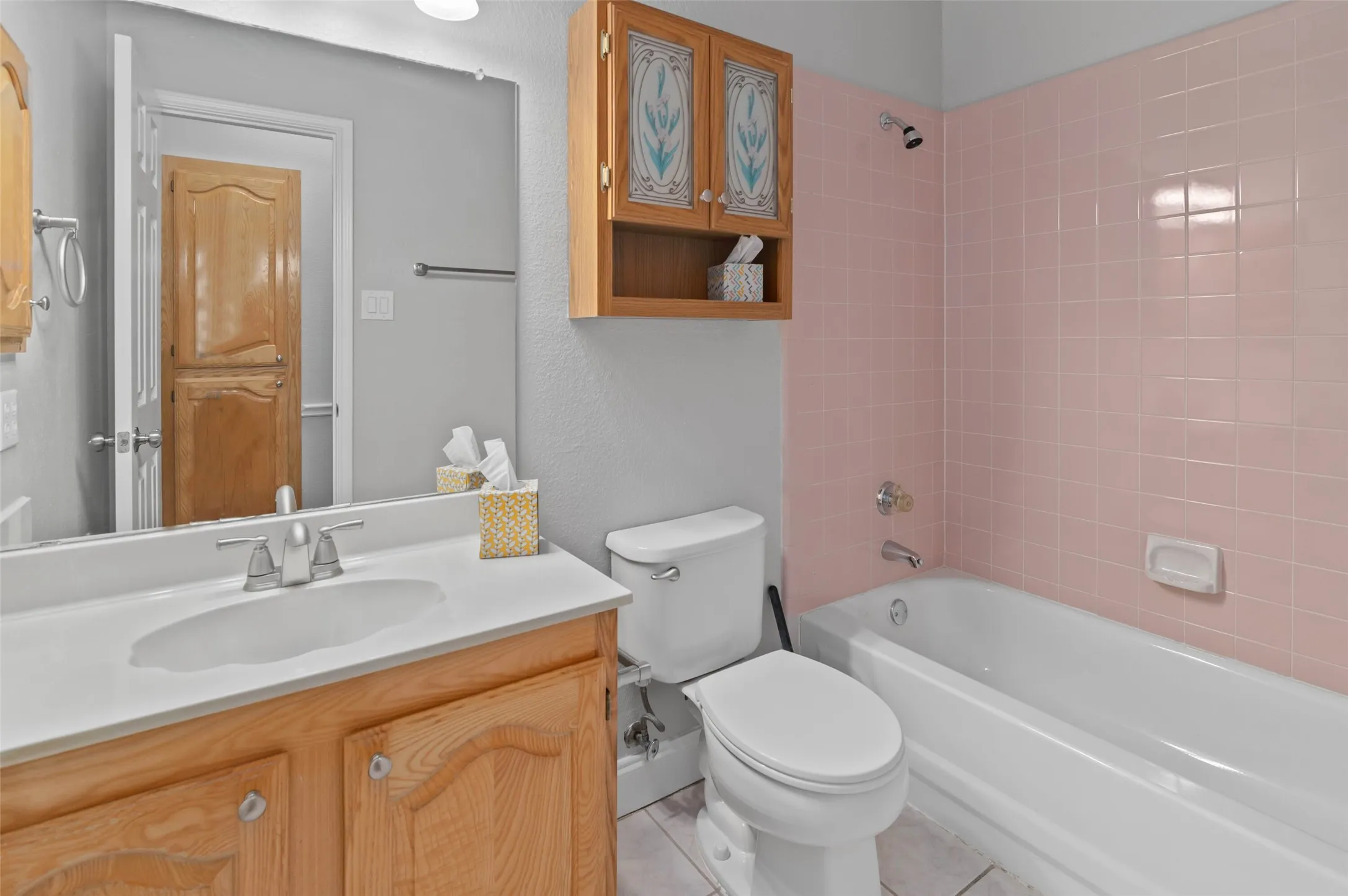 Secondary bathroom with decorative tile and ceramic tile flooring.