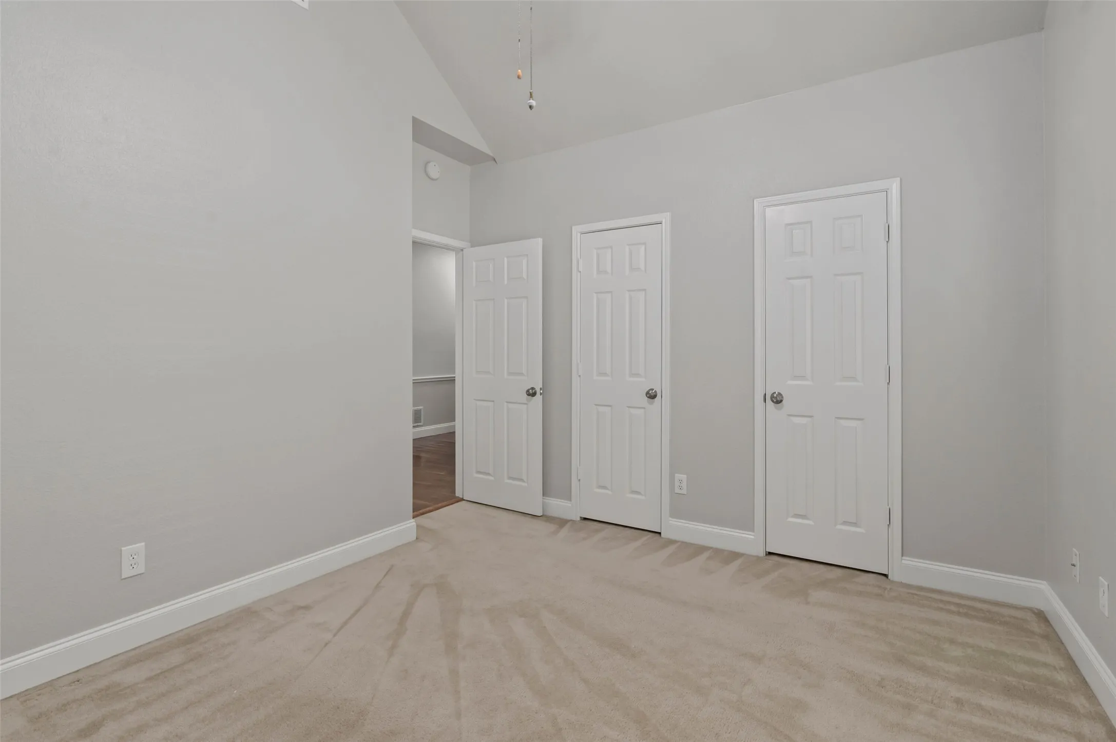 Spacious bedroom with carpeted flooring, ceiling fan and dual closets.