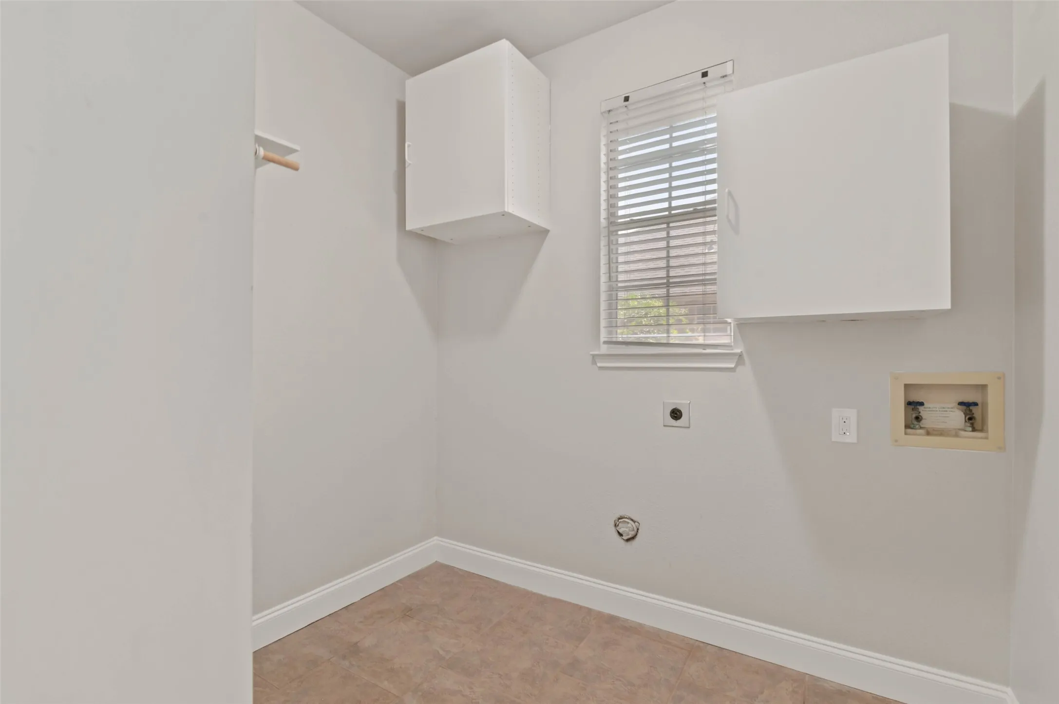 Laundry room with built in cabinets, ceramic tile flooring and full-size washer and dryer hookup.