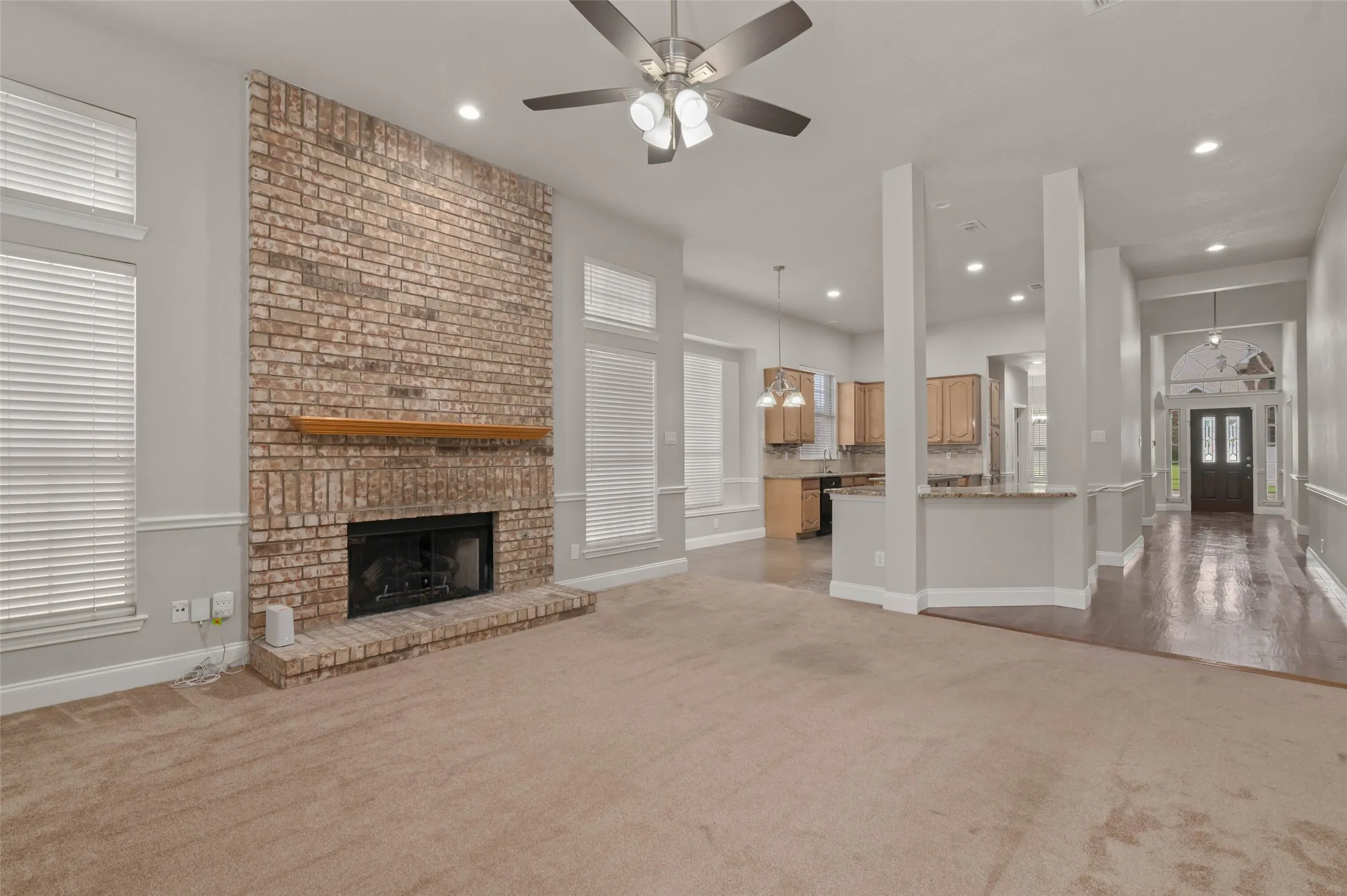Spacious living area with plenty of windows, gas fireplace and back door opening to the beautiful back yard and pool area.