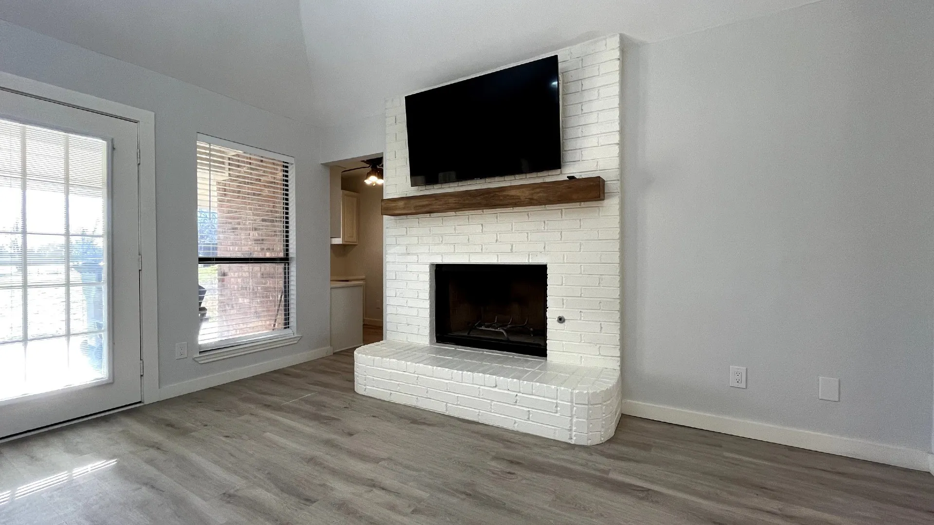 White-painted brick fireplace with a wood mantle