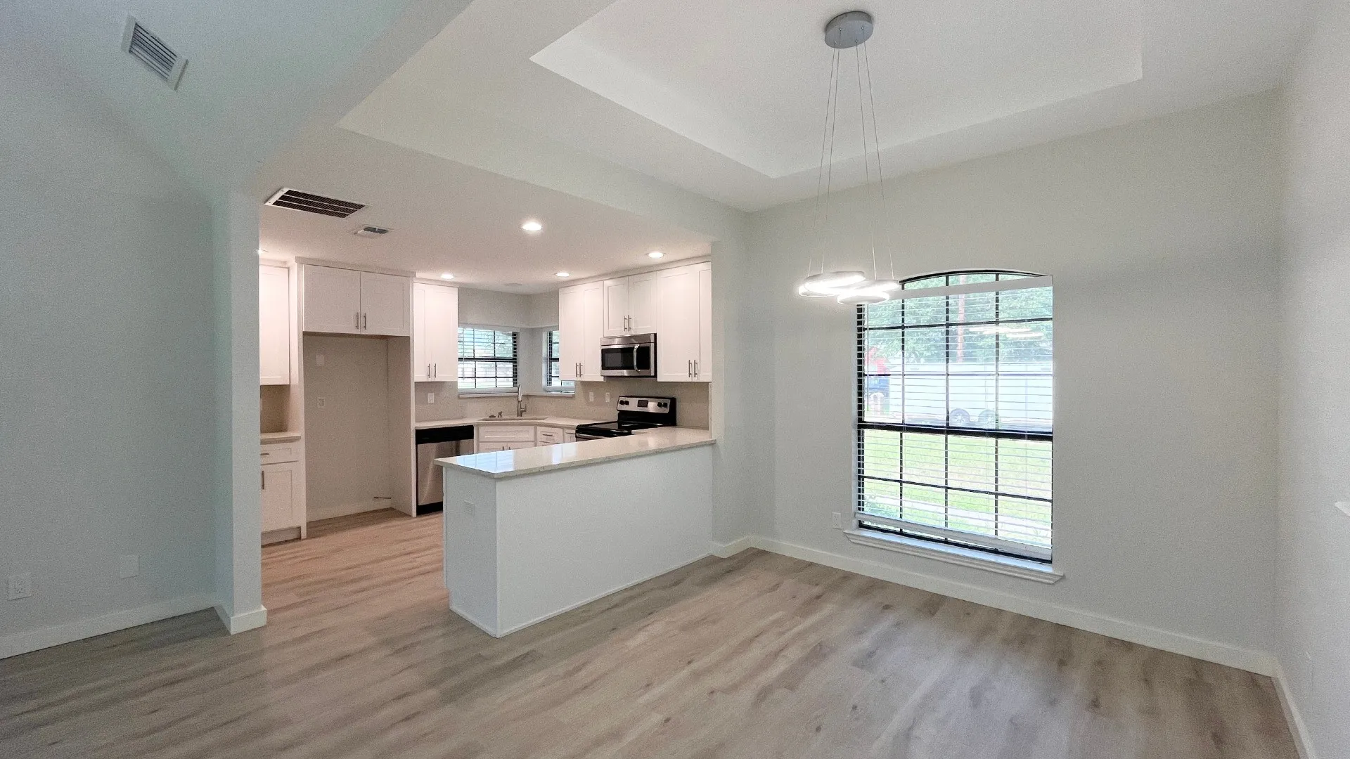 Kitchen with white cabinetry, stainless steel appliances, and light countertops