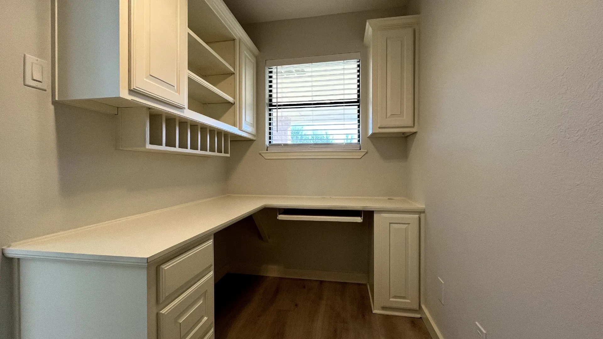 Built-in L-shaped desk with a light-colored countertop