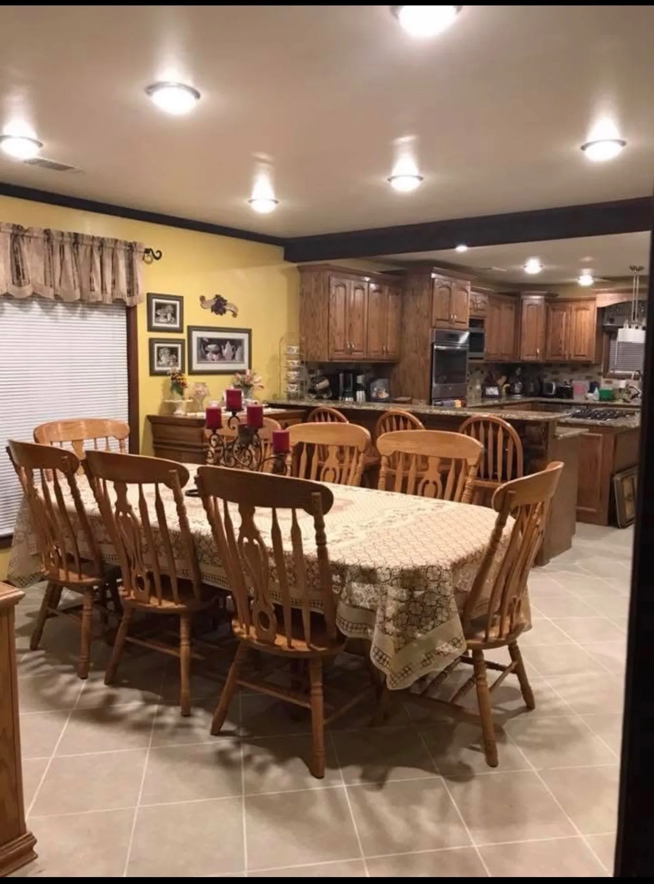 Recessed lighting, tile flooring, wood-finish cabinetry, and a built-in kitchen island with seating