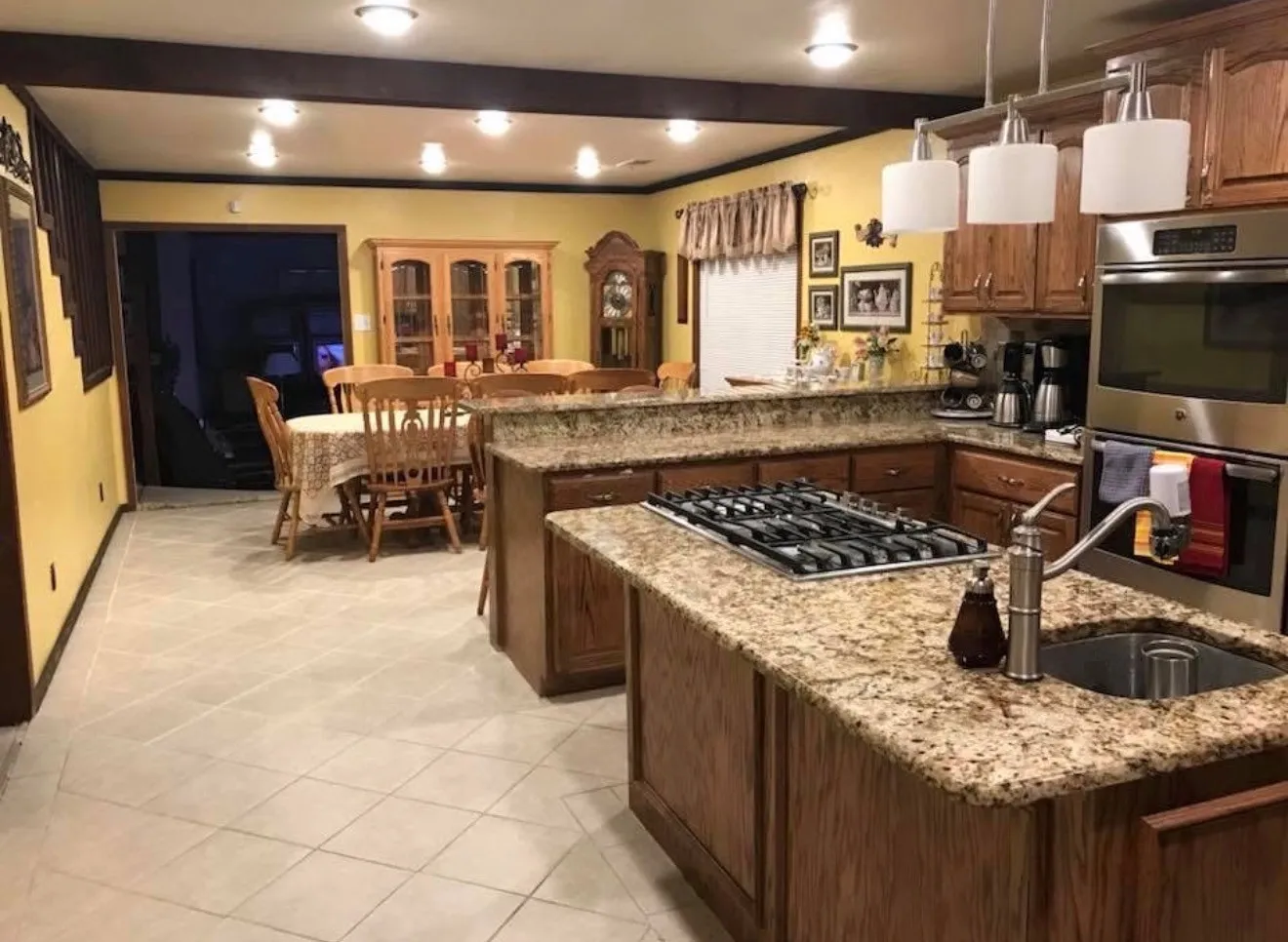 Granite countertops, integrated gas cooktop, stainless steel built-in oven, pendant lighting, and recessed ceiling lighting