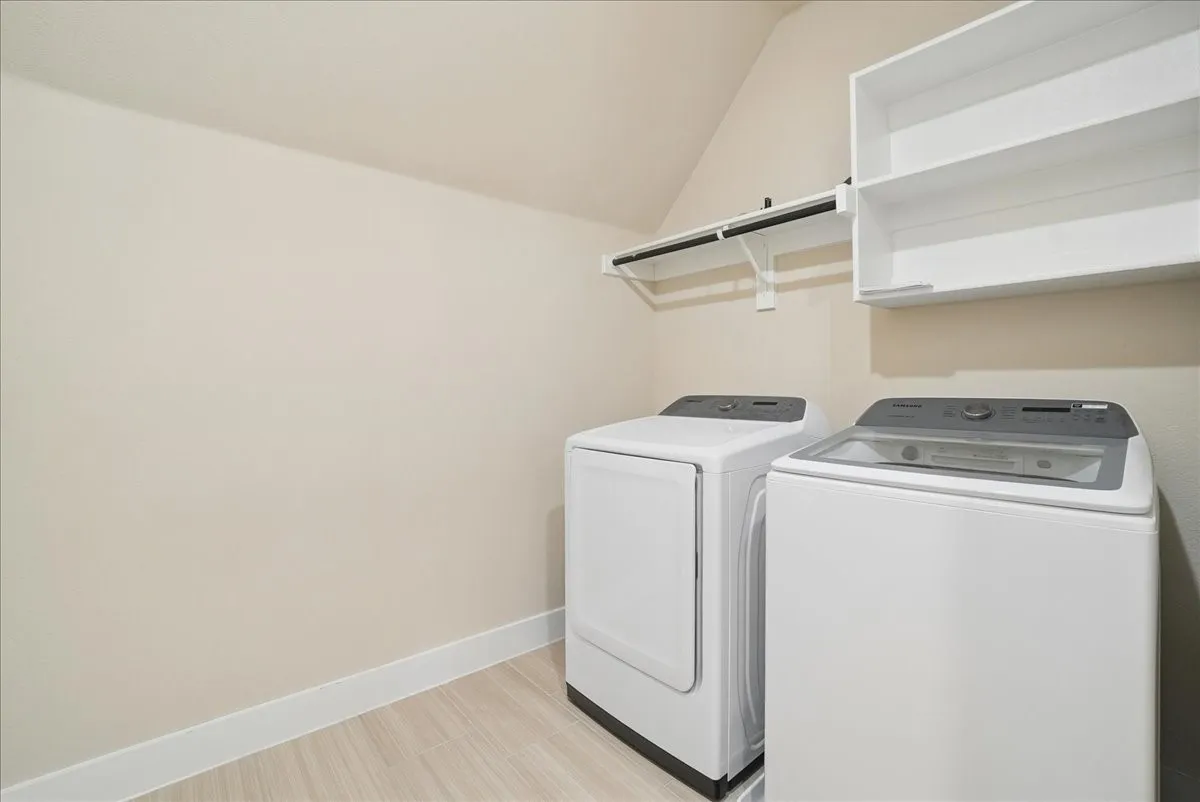 Sloped ceiling, wood-finish flooring, white wall shelving, and a hanging rod