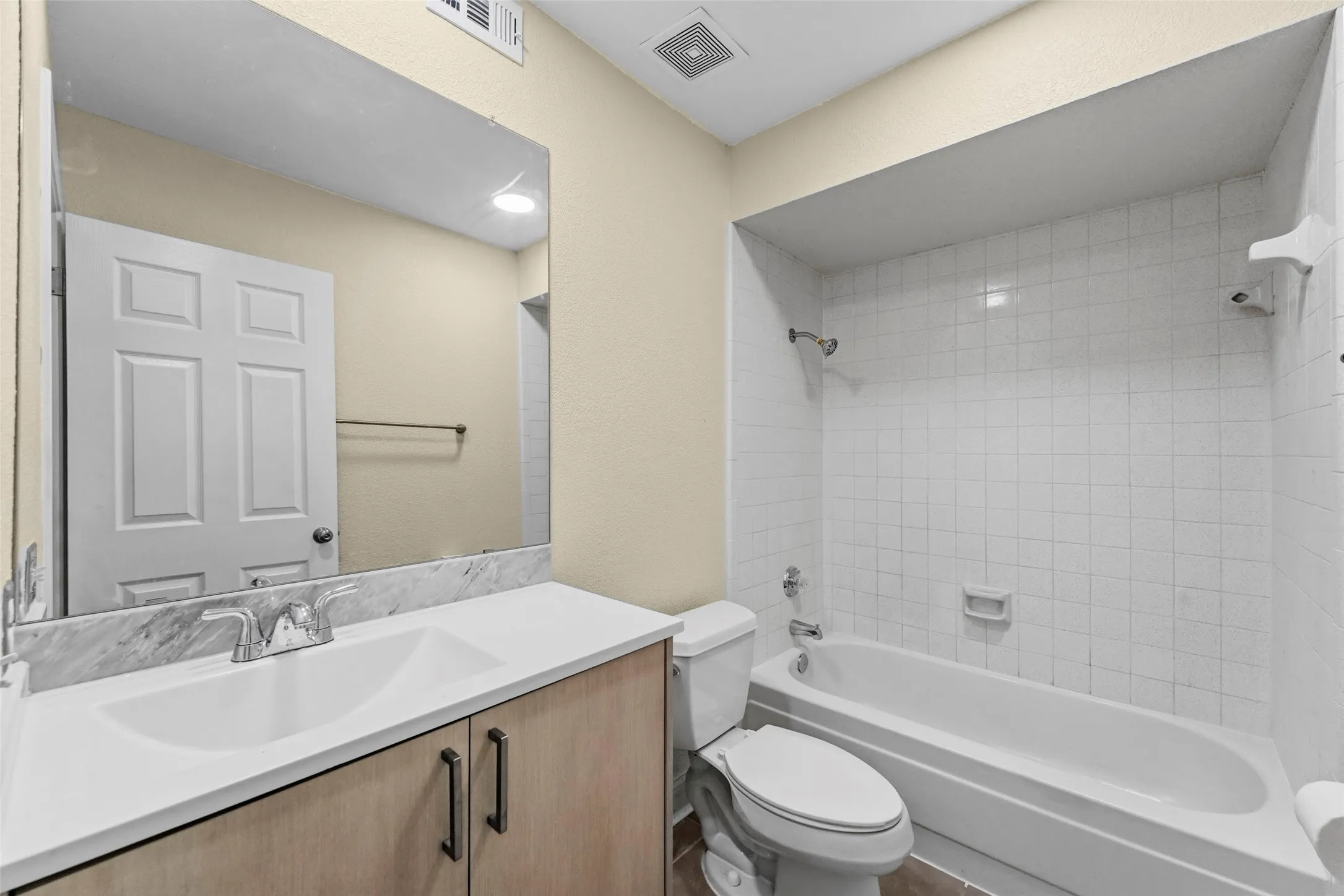Vanity with dual sinks, a large mirror, and wood-finish cabinetry