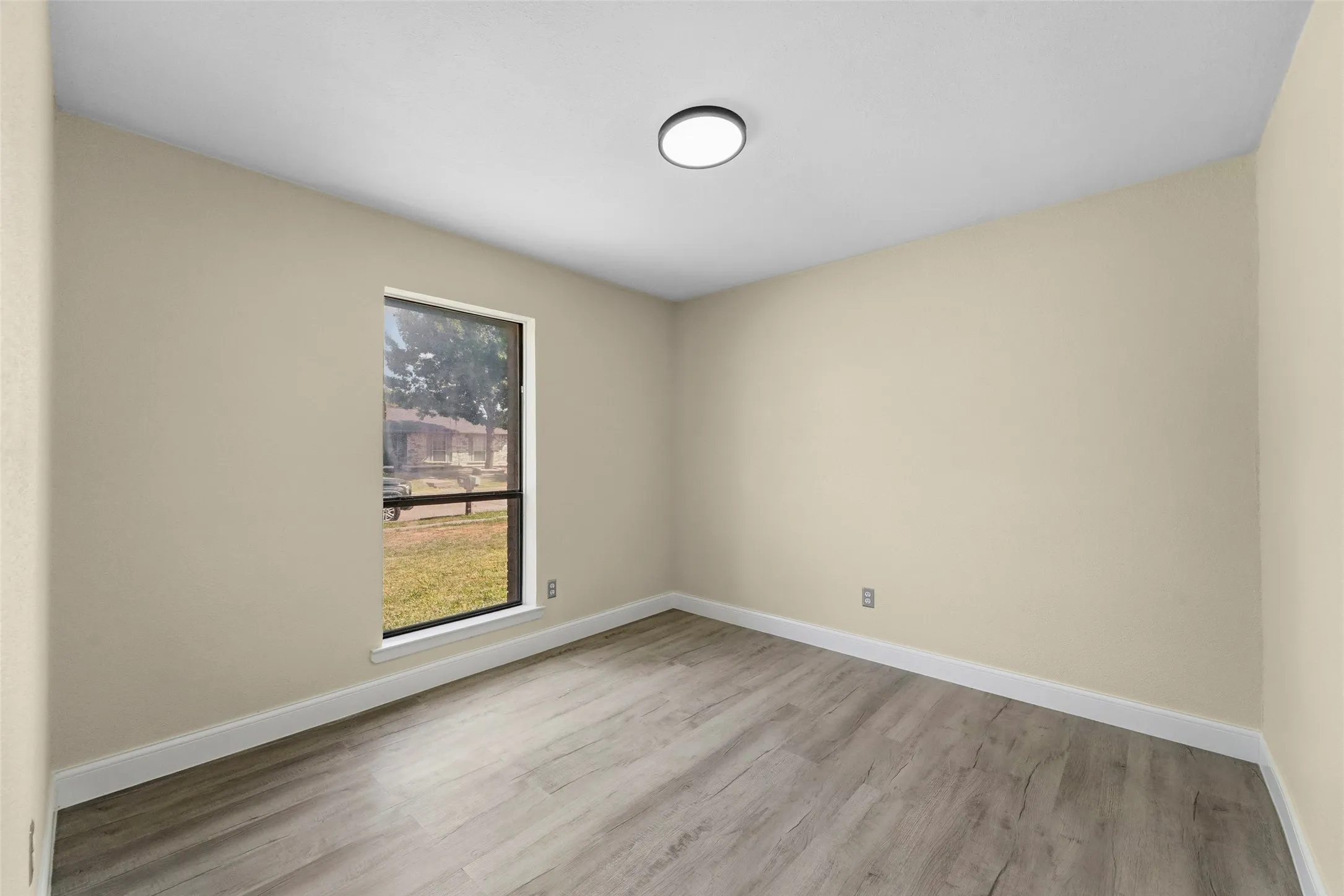 Recessed lighting fixture, light-toned walls, wood-finish flooring, and white trim