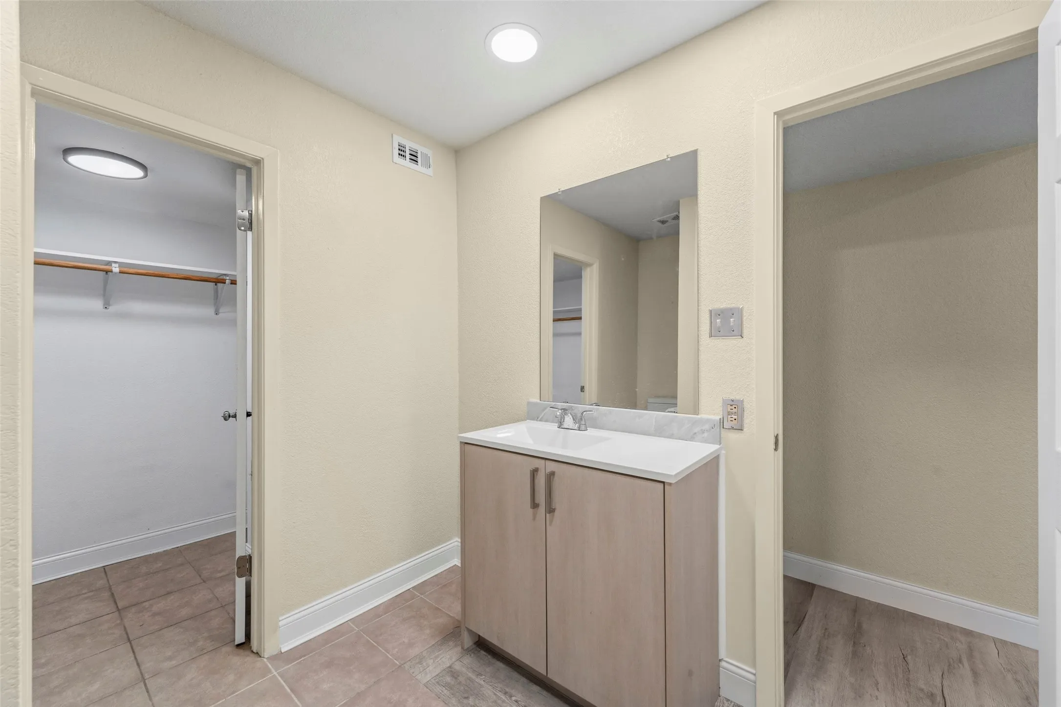 Single vanity with a white countertop and integrated sink