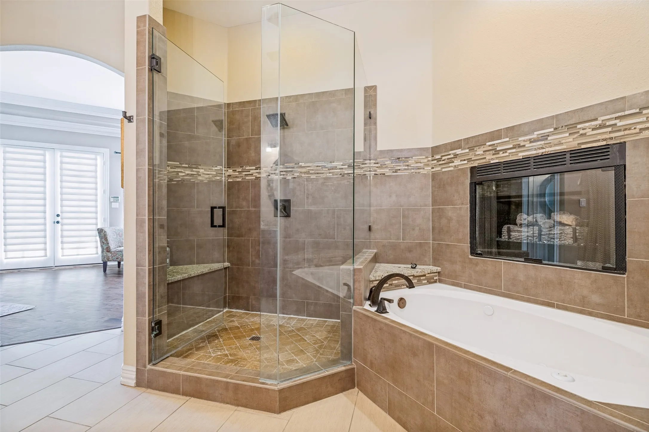 Frameless glass shower enclosure and separate tub.