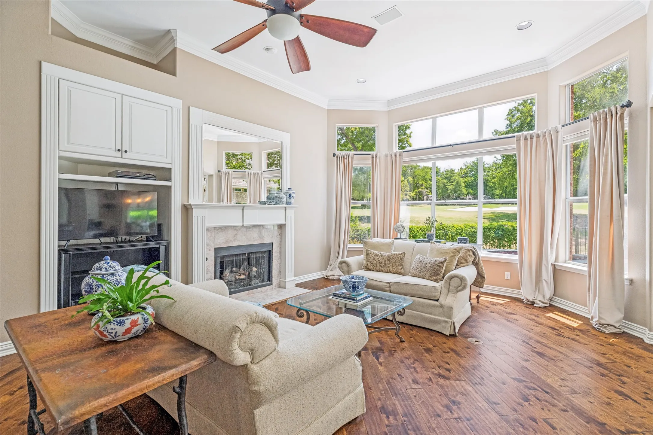 The living room is full of natural light and views of the golf course.