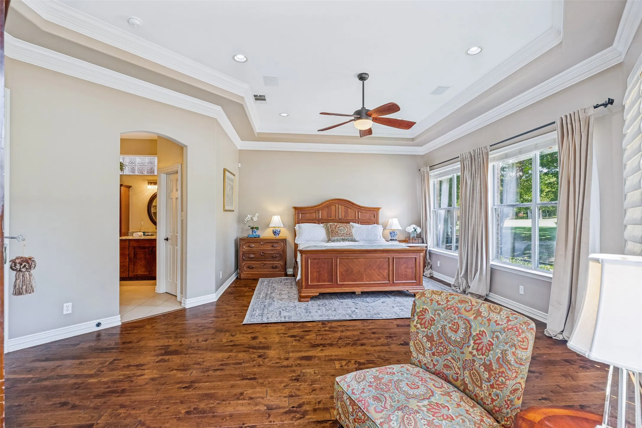 Huge primary retreat with sitting area, built-ins, a beautiful tiered ceiling and wall of windows.