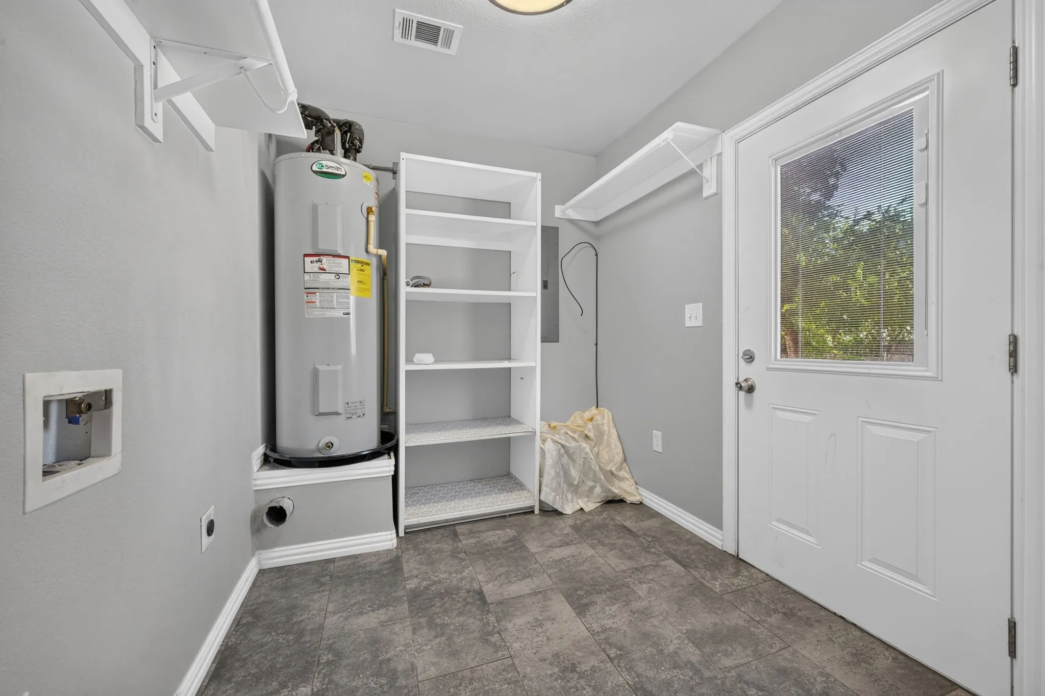 Utility area featuring a 50 gallon water heater, built-in shelving, and a door with a window