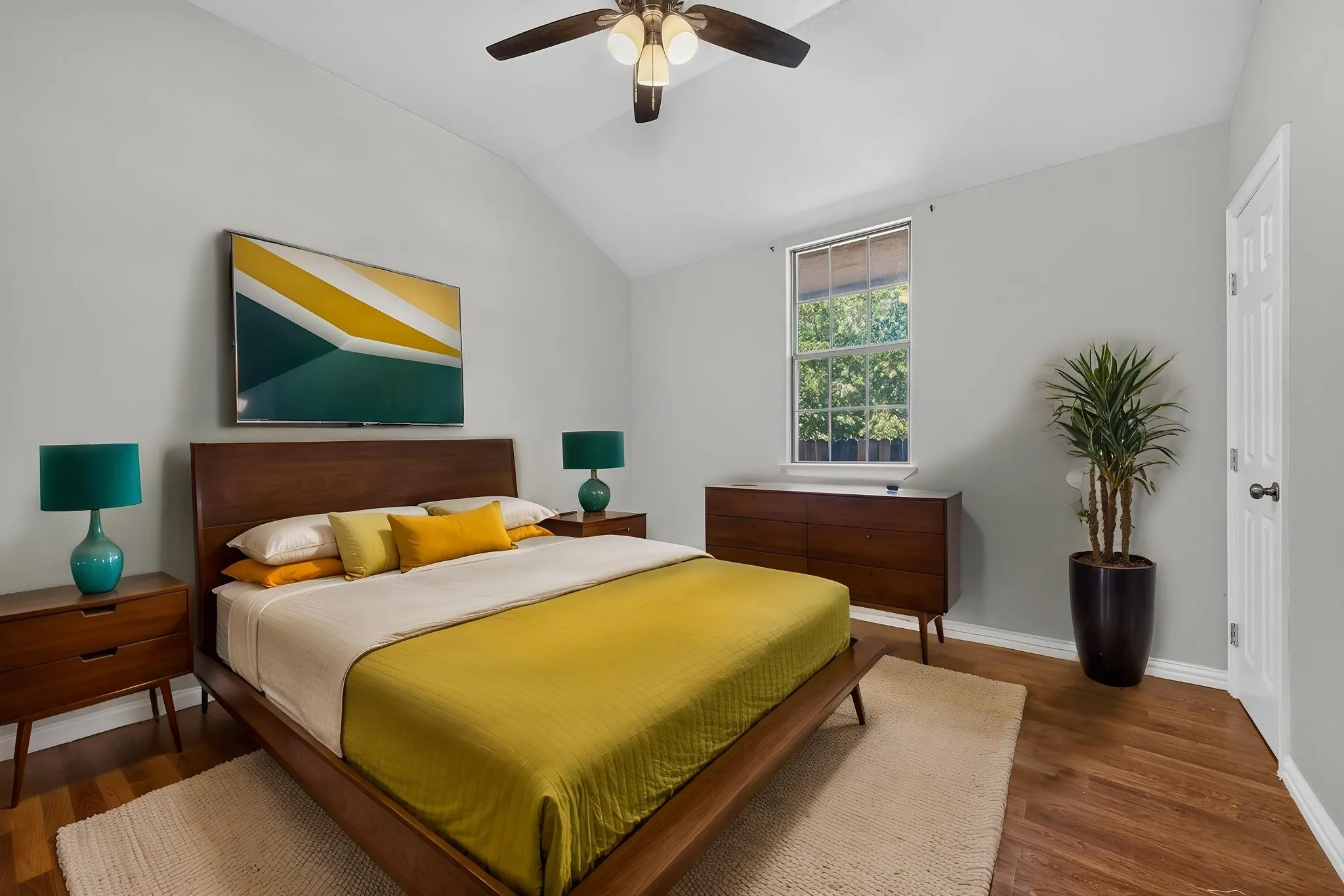 Vaulted ceiling with a ceiling fan, wood-look finish flooring, and a single window