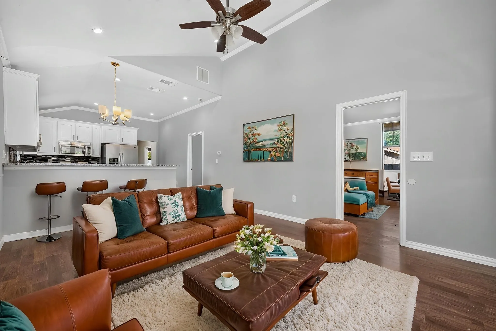 Vaulted ceilings in the living area, wood-look finish flooring, a breakfast bar, recessed lighting, and a ceiling fan