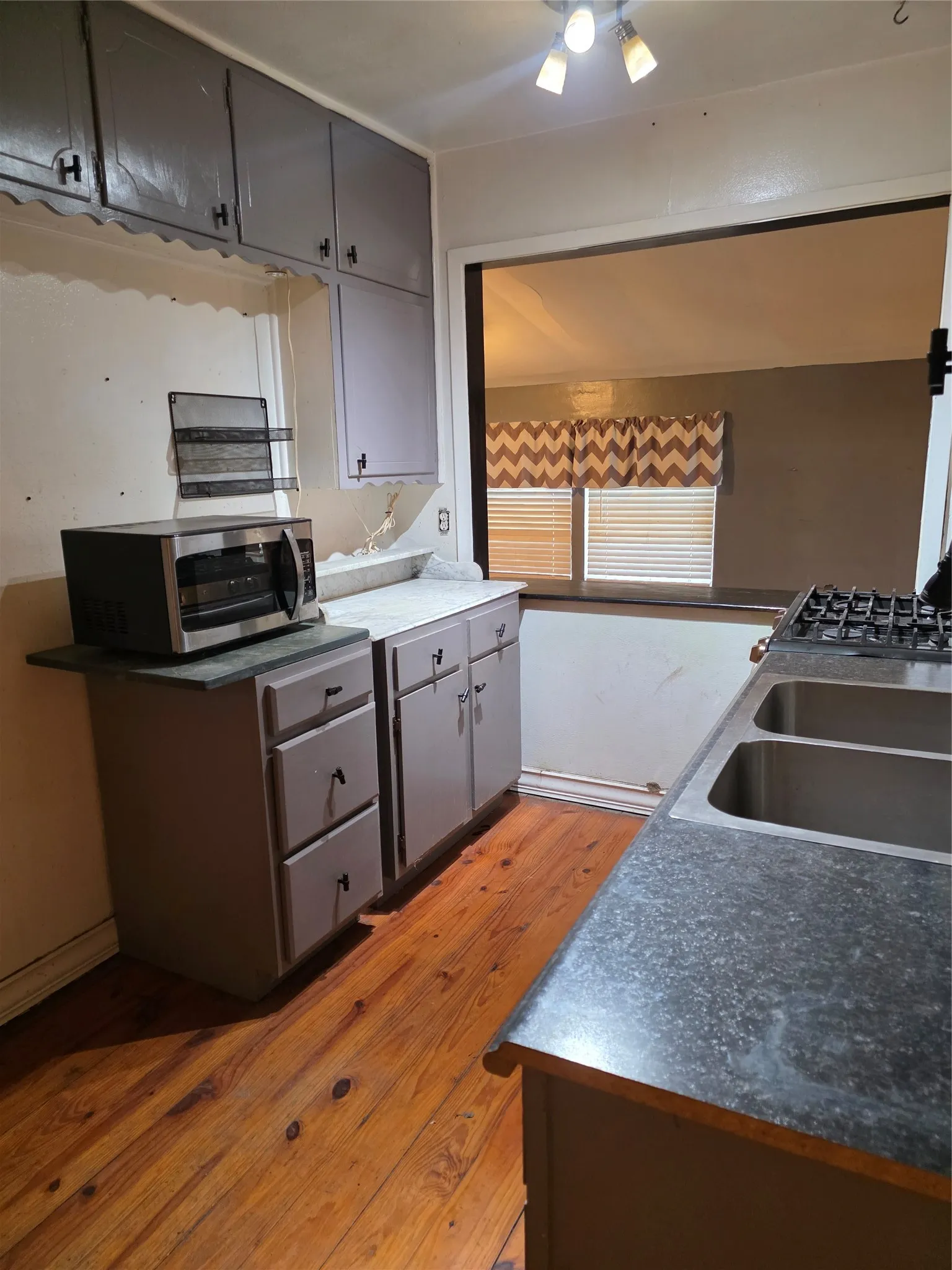 Wood-finish flooring with grey cabinetry and built-in double basin sink